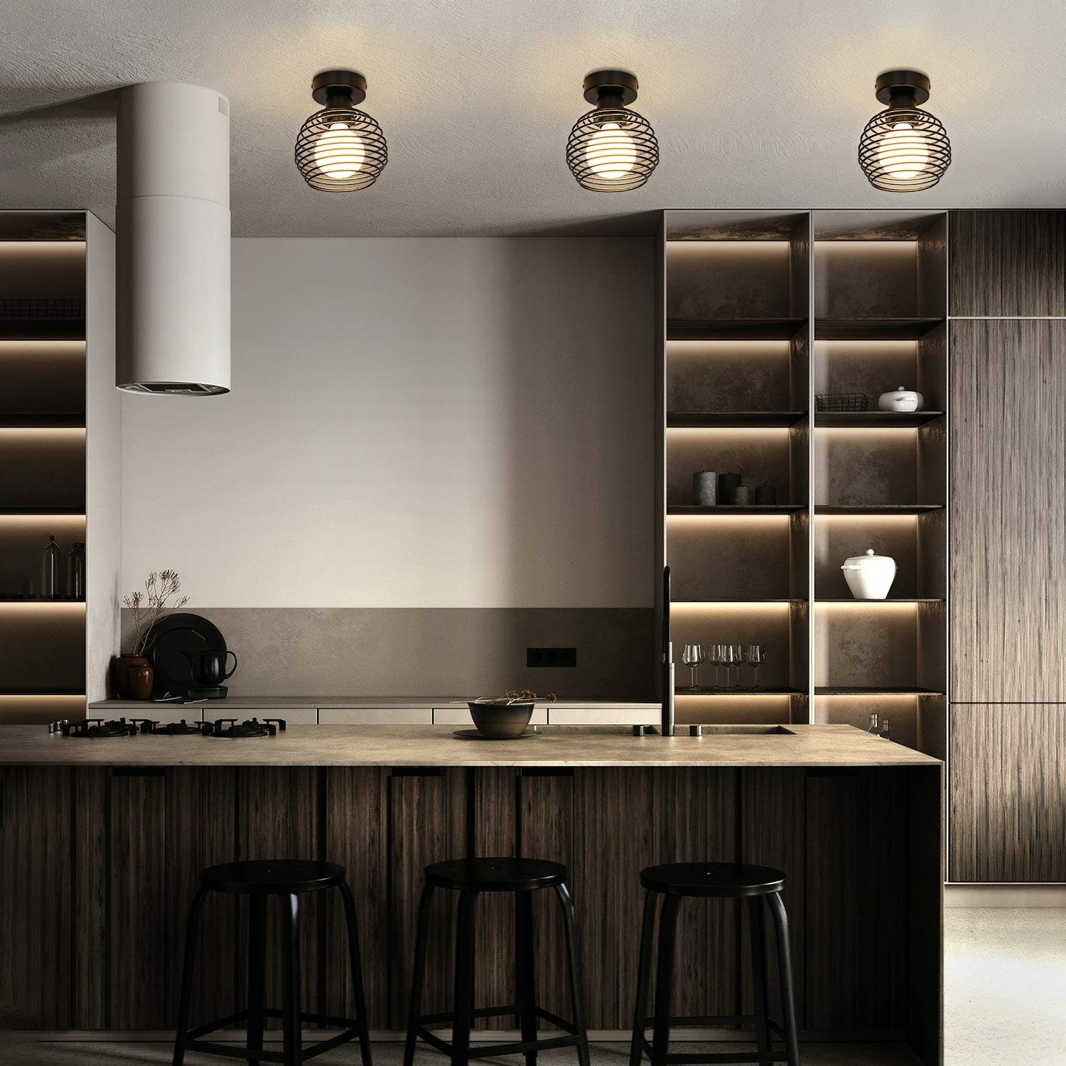 Nowoczesna kuchnia z trzema lampami wiszącymi nad wyspą kuchenną.