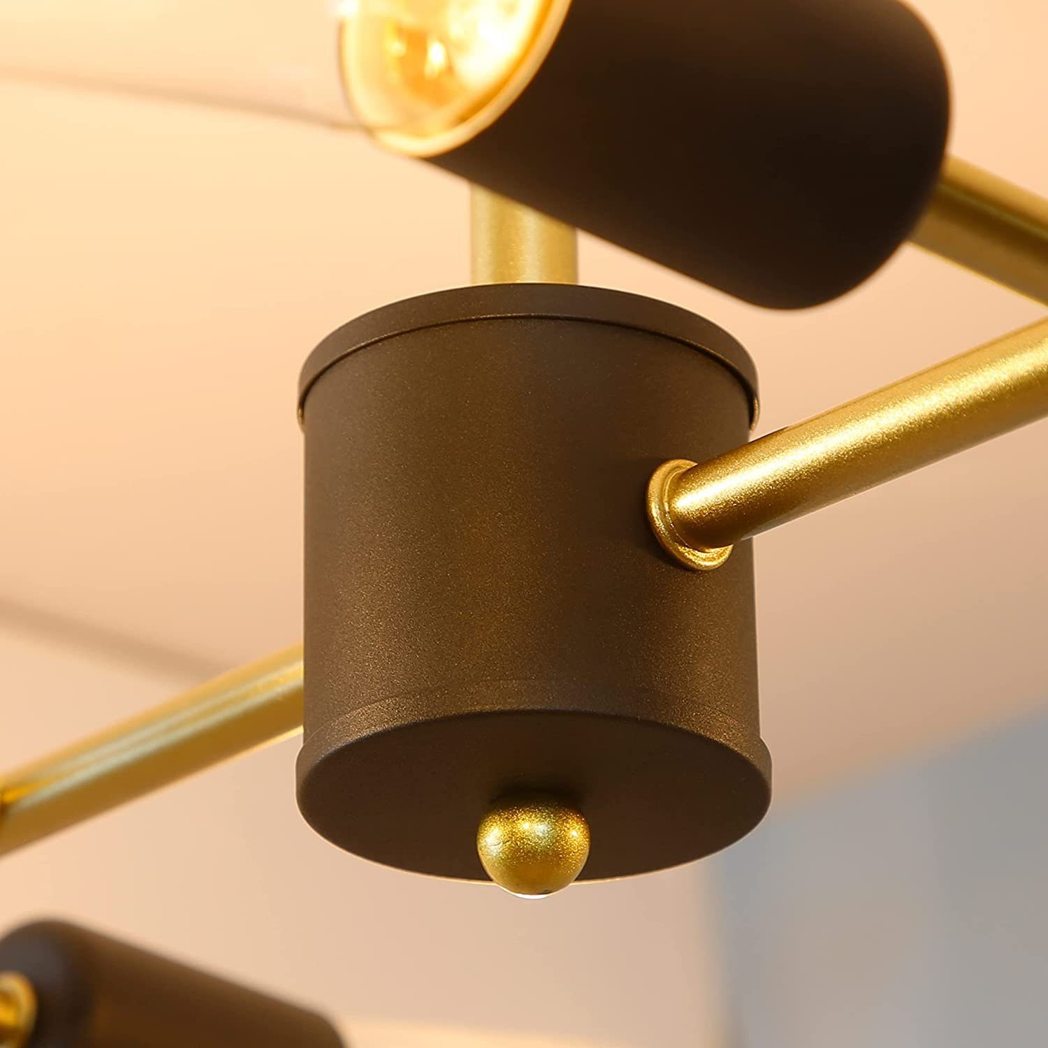 Zbliżenie nowoczesnej lampy sufitowej z czarnymi i złotymi akcentami.