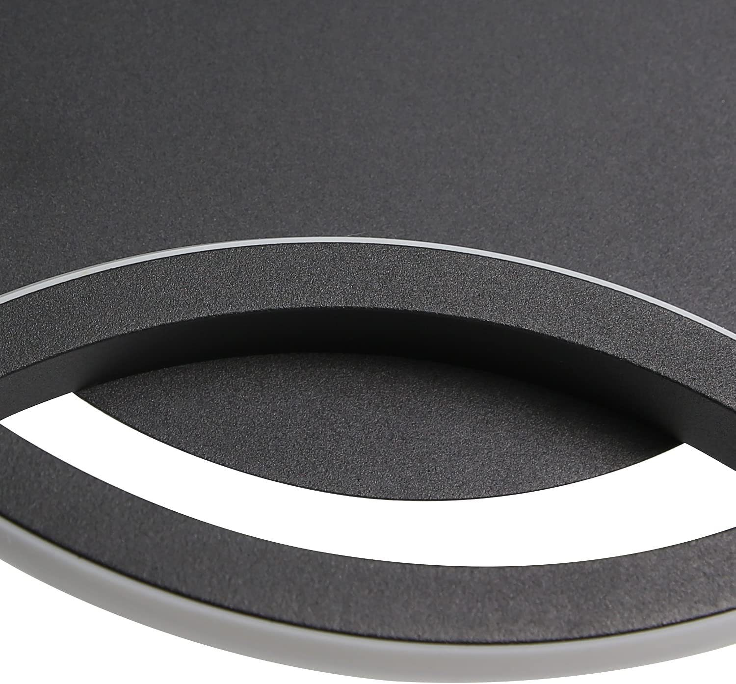 Zbliżenie ciemnej, teksturowanej powierzchni z białym obramowaniem i zakrzywioną krawędzią.