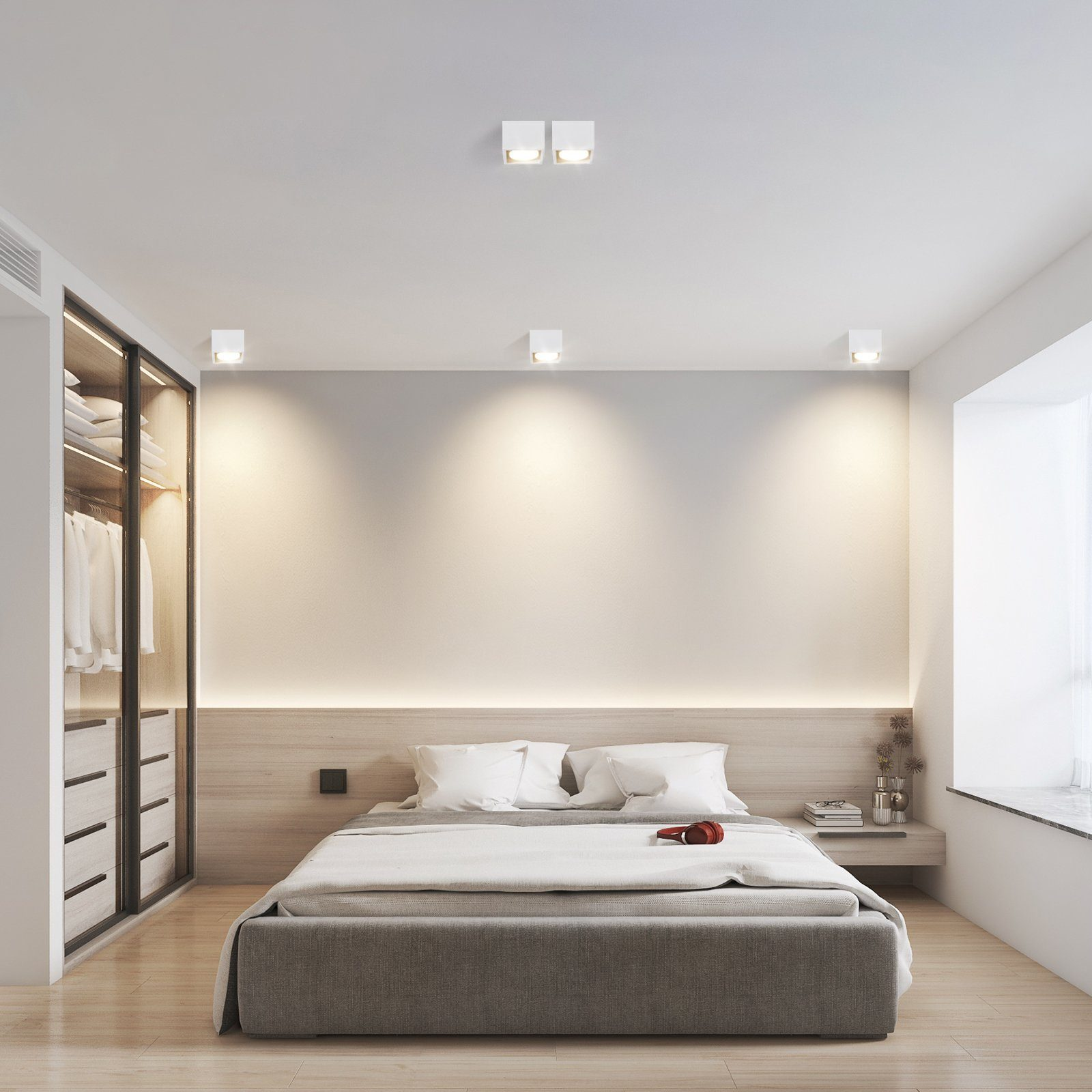 Una camera da letto con letto, armadio e tre luci a soffitto. La scena è ben illuminata e moderna.