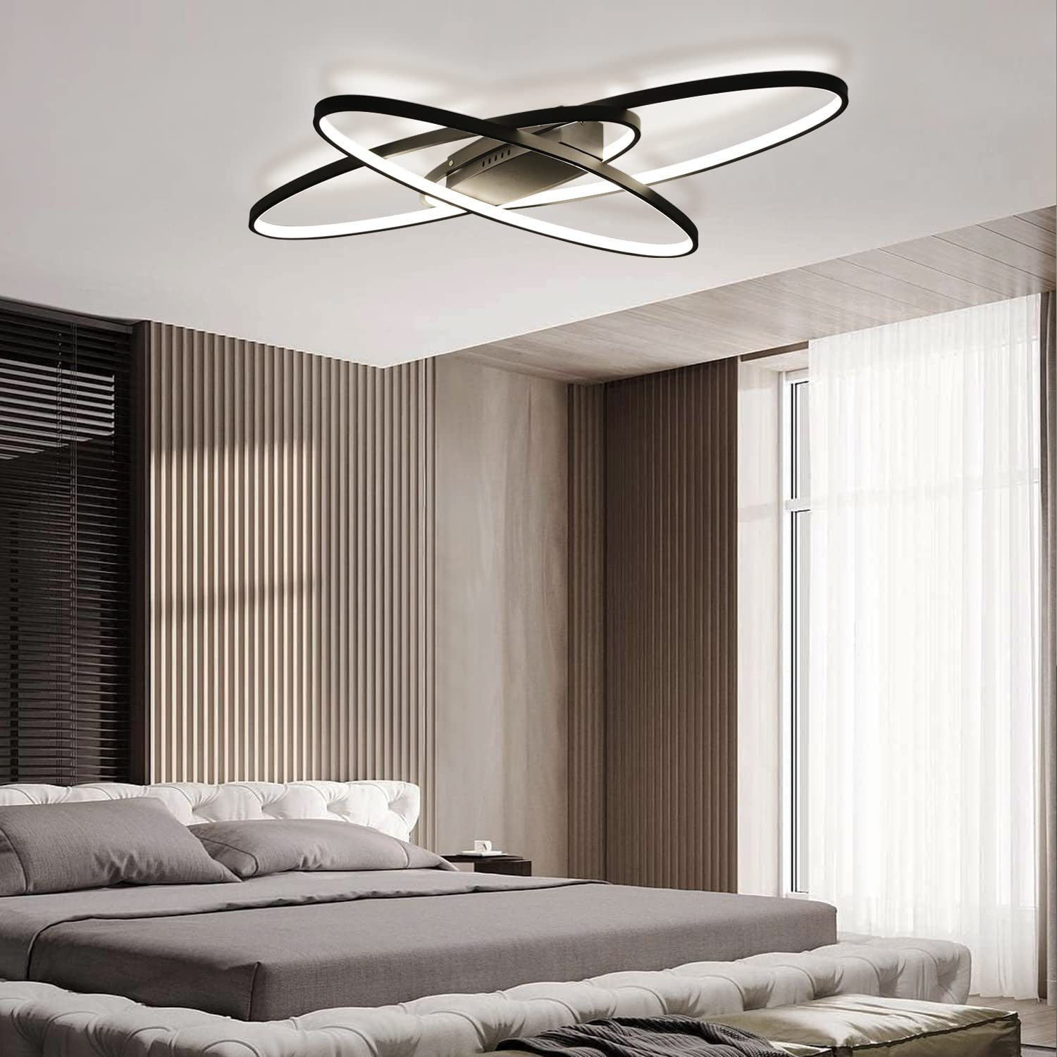 Lampada da soffitto in bianco e nero con elementi curvi intersecanti sopra un letto.