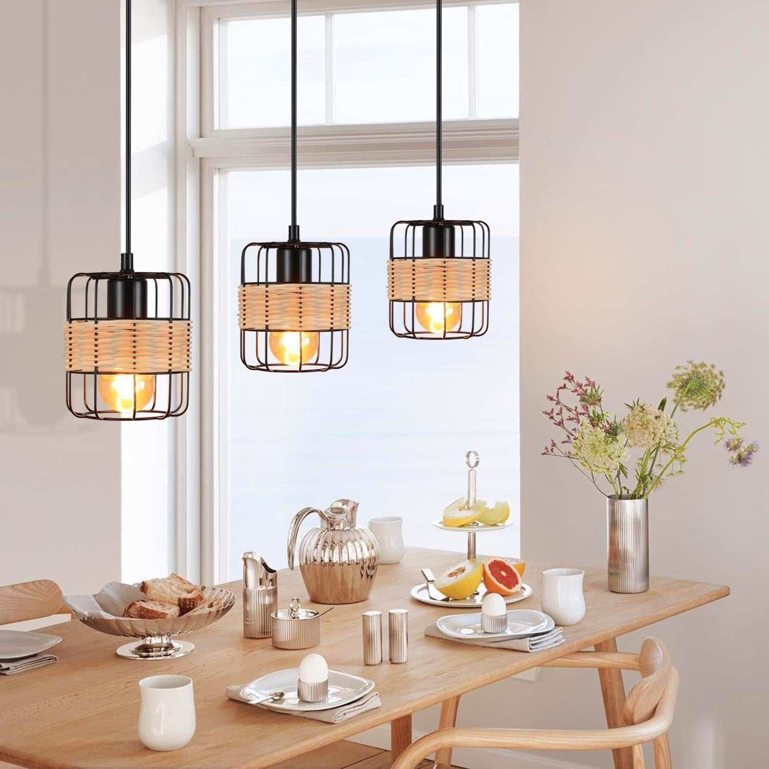 Stół jadalniany z trzema lampami wiszącymi, jedzeniem i dekoracjami.