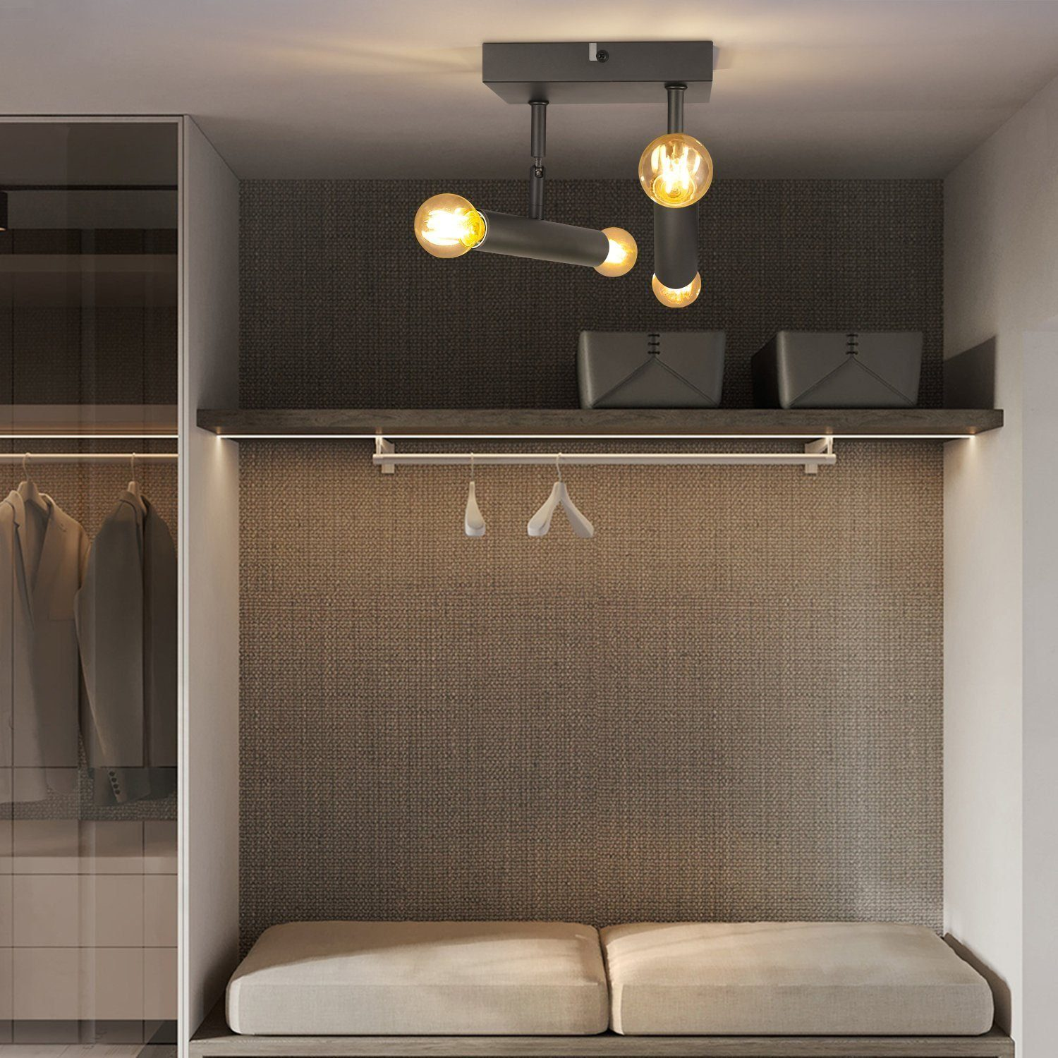 Nowoczesna lampa sufitowa z czterema żarówkami w ciemnoszarym pokoju z ławką i ubraniami.