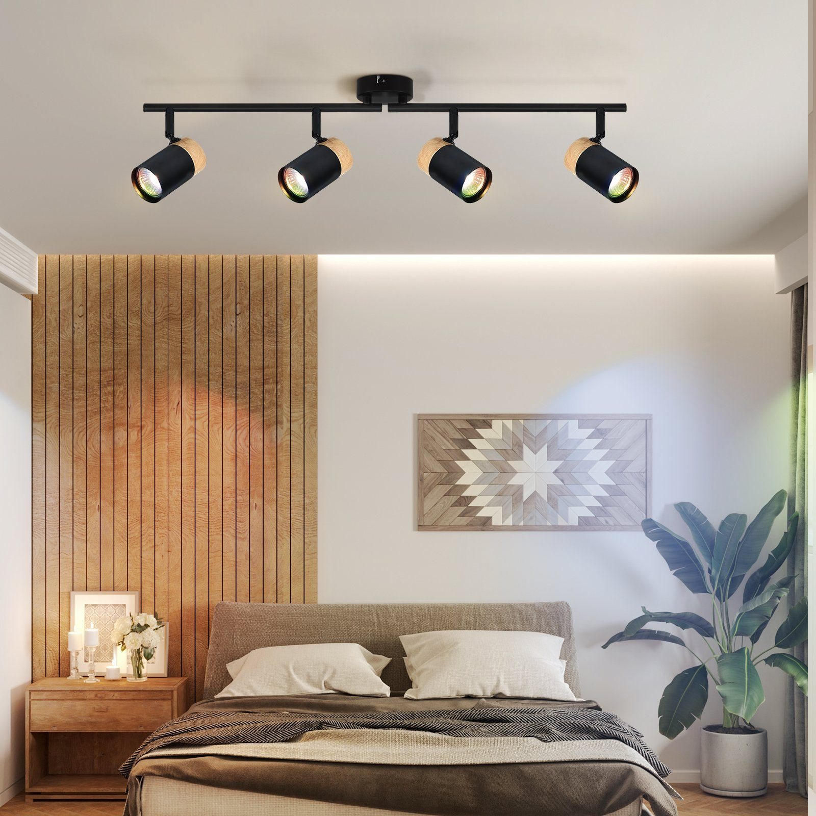 Una camera da letto con un lampadario. Quattro faretti su una barra nera, con mobili da camera da letto.