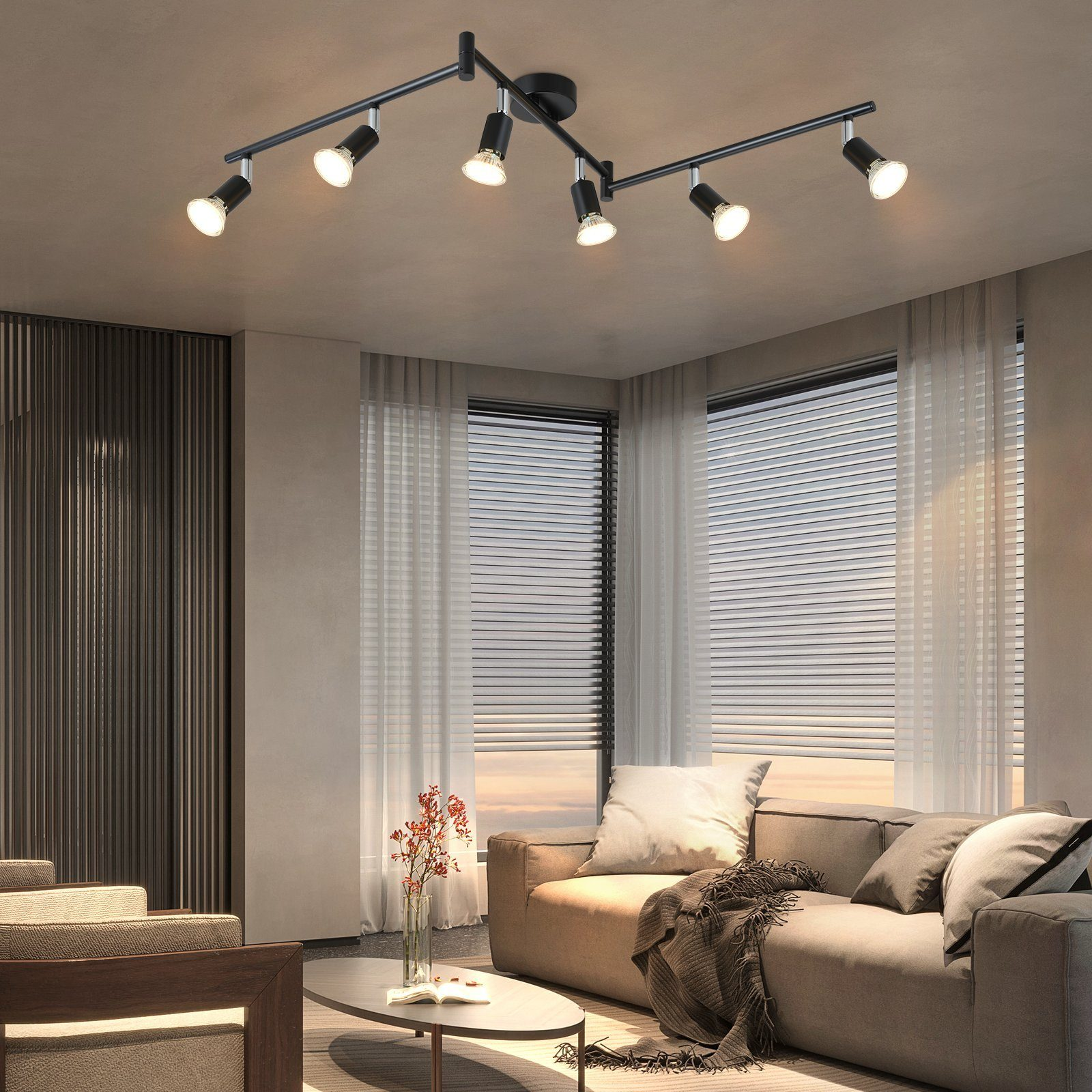 Salon z oświetleniem szynowym z siedmioma lampami i brązową sofą.