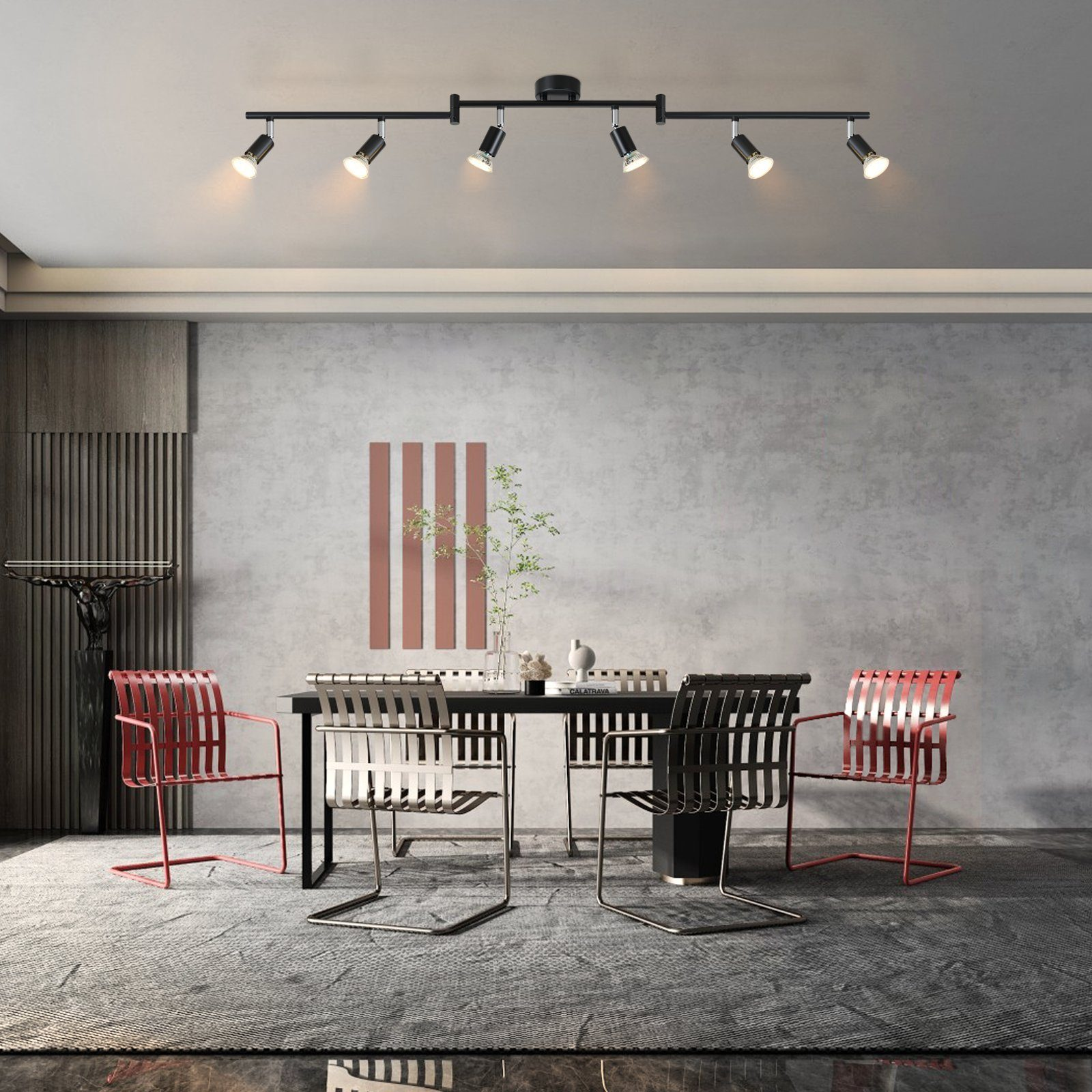 Jadalnia z czarnym stołem, krzesłami i systemem oświetlenia szynowego. Obraz na ścianie.