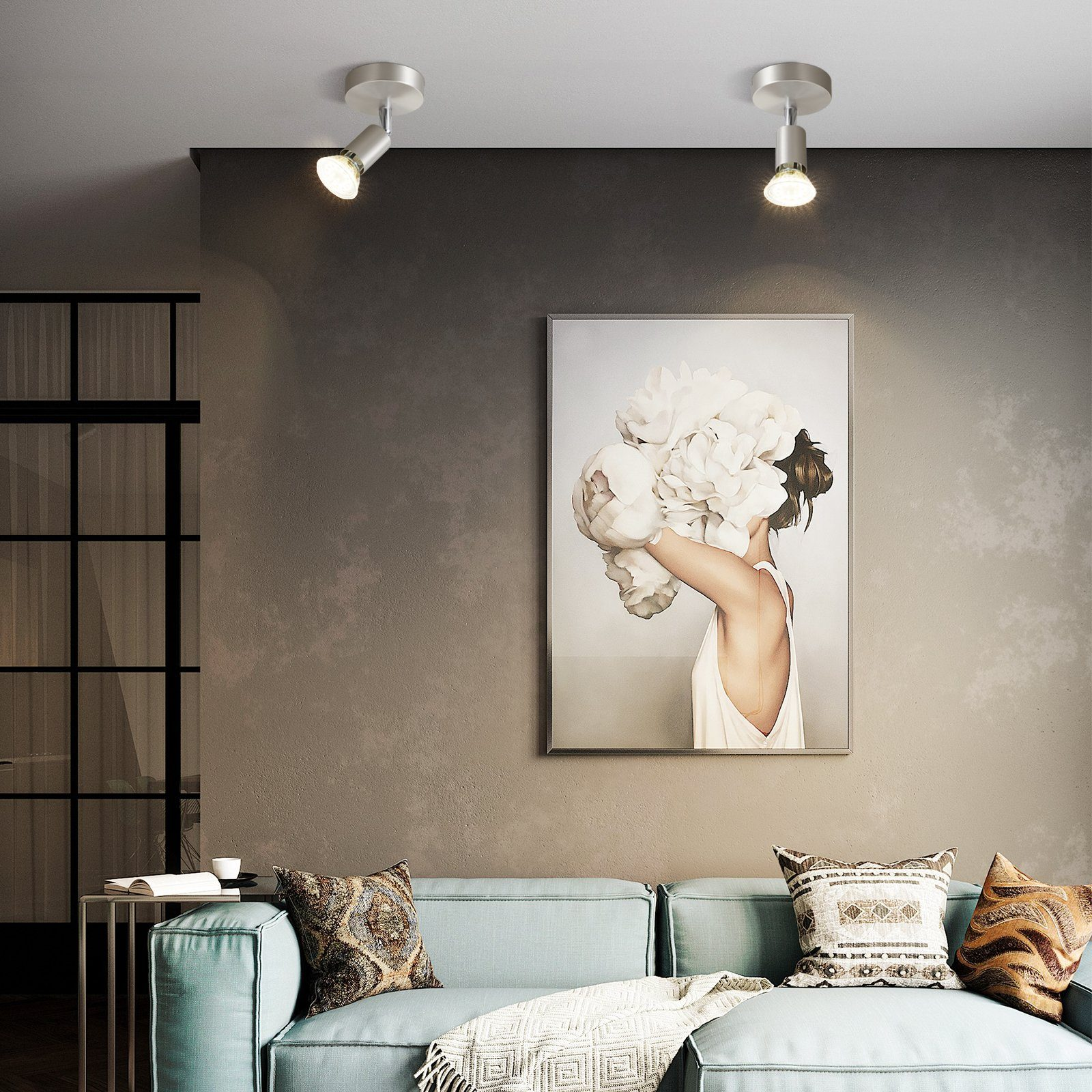 Dwa srebrne reflektory na suficie. Zdjęcie kobiety z kwiatami na ścianie.