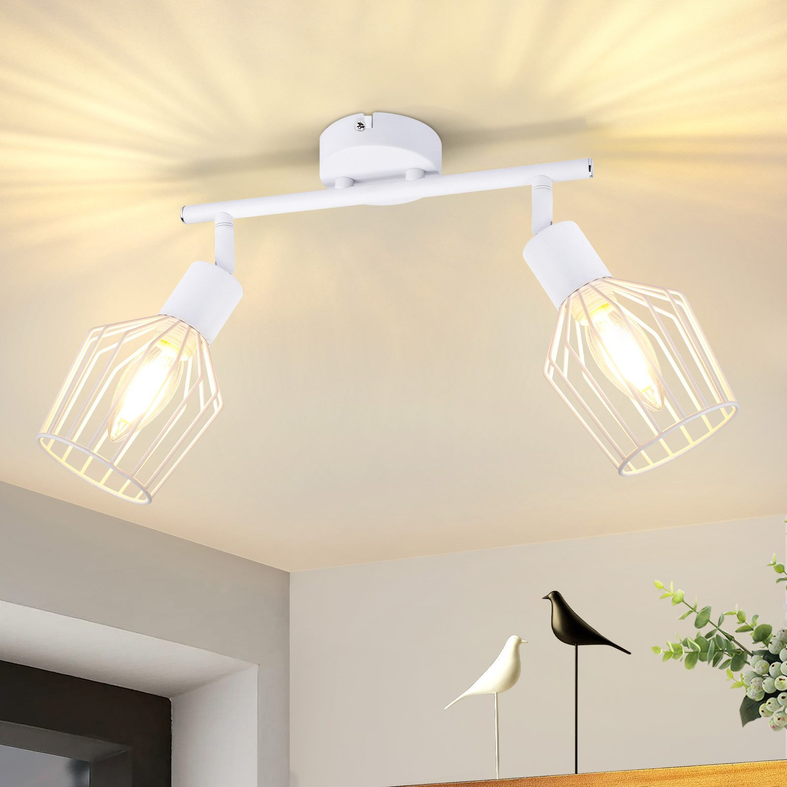 Dwa światła na białym pręcie. Światła mają konstrukcję przypominającą klatkę. Światła są włączone.