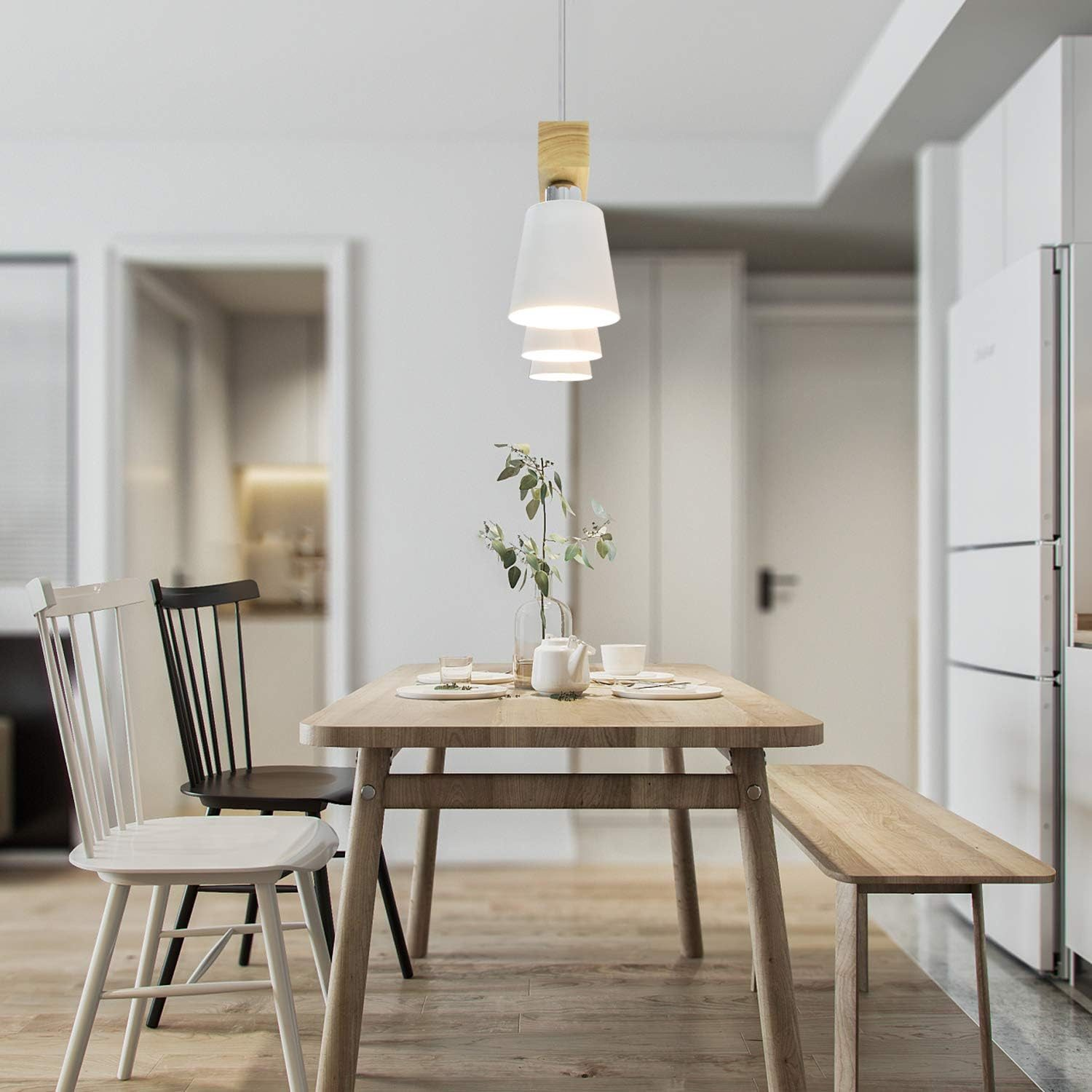 Sala da pranzo con tavolo in legno, sedie e un lampadario bianco appeso al soffitto.