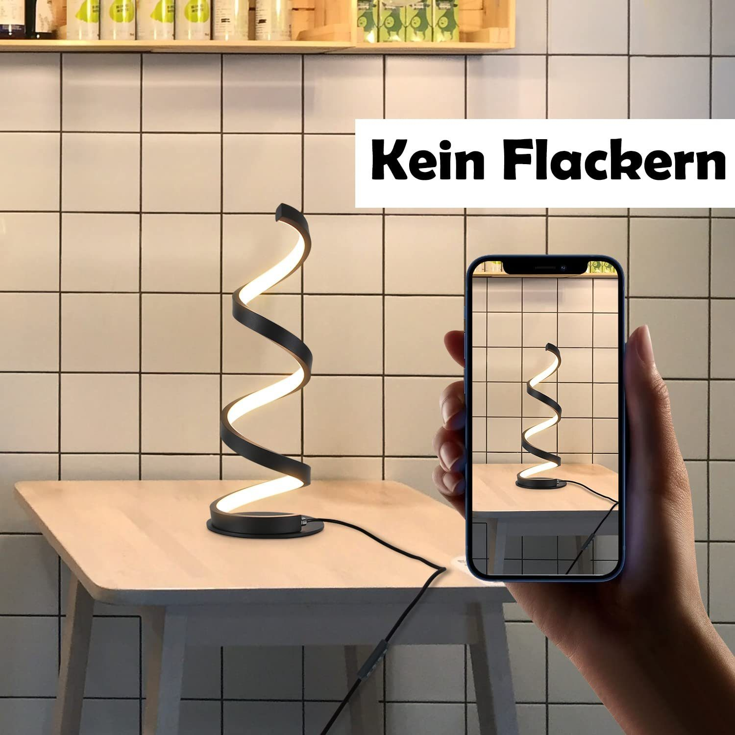 Czarna, spiralna lampa na drewnianym stole. Telefon pokazuje lampę. Tło to kafelkowa ściana.