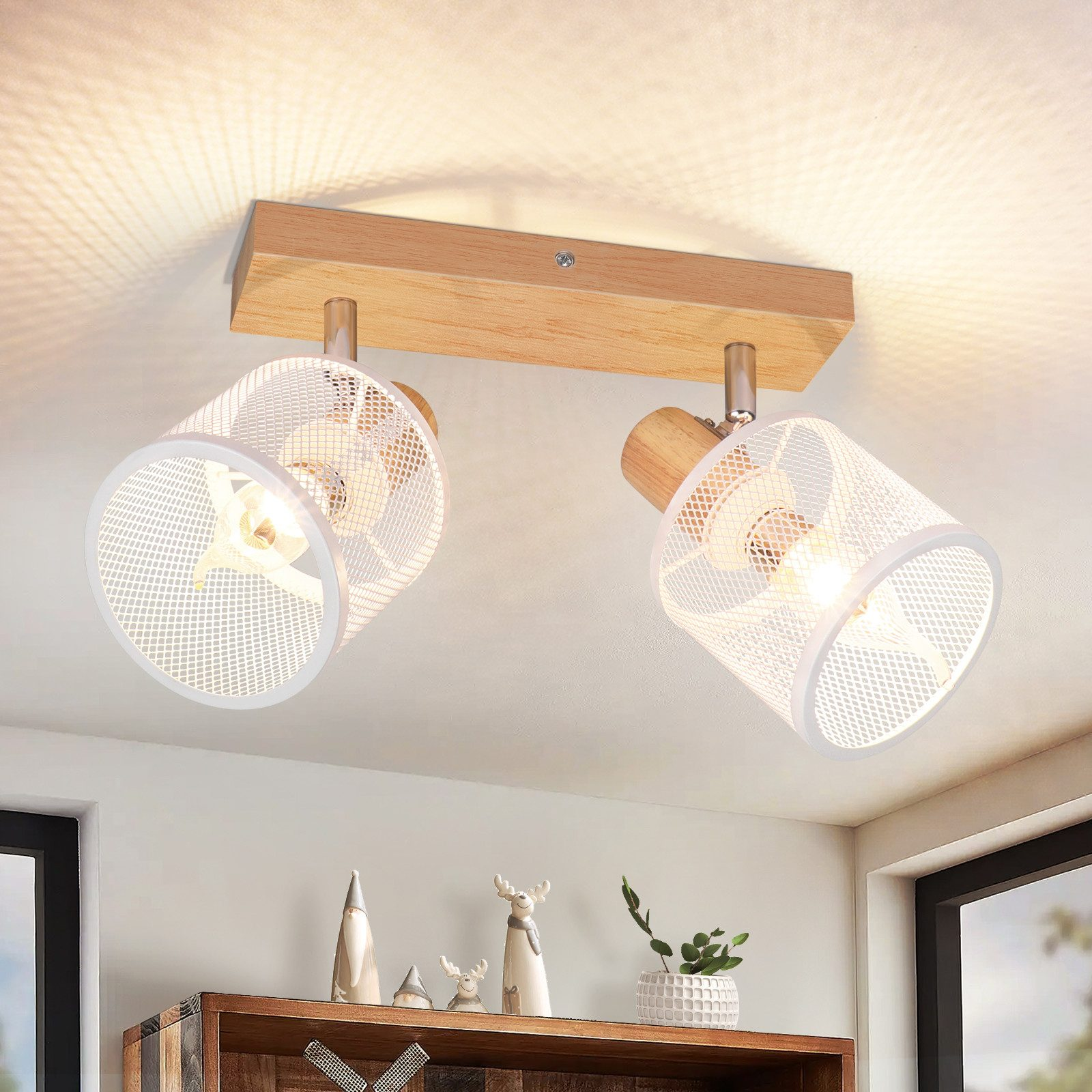 Due faretti montati su una trave di legno fissata al soffitto. Un mobile in legno è visibile sotto.