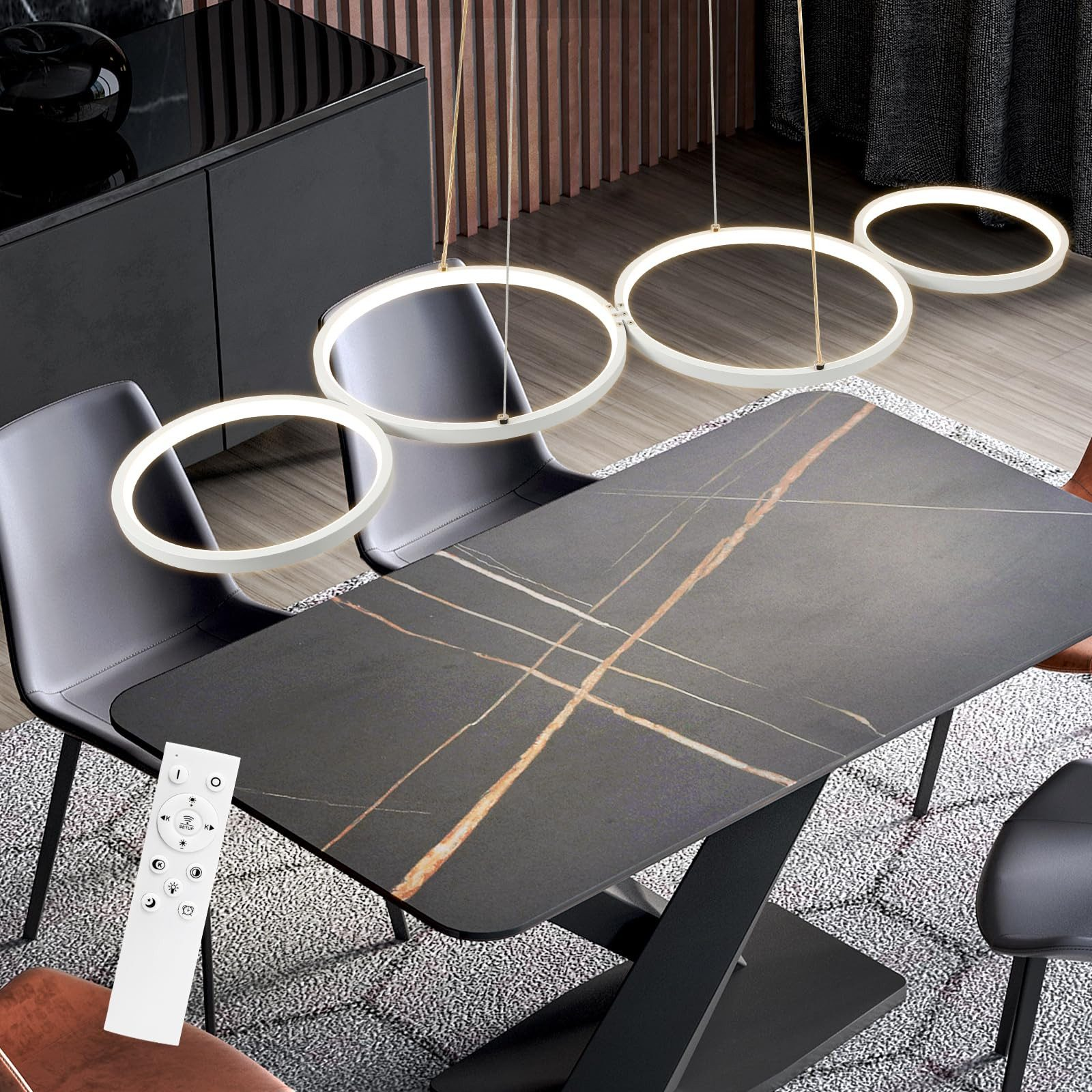 Sala da pranzo con quattro lampade a sospensione circolari bianche, un tavolo nero e un telecomando.