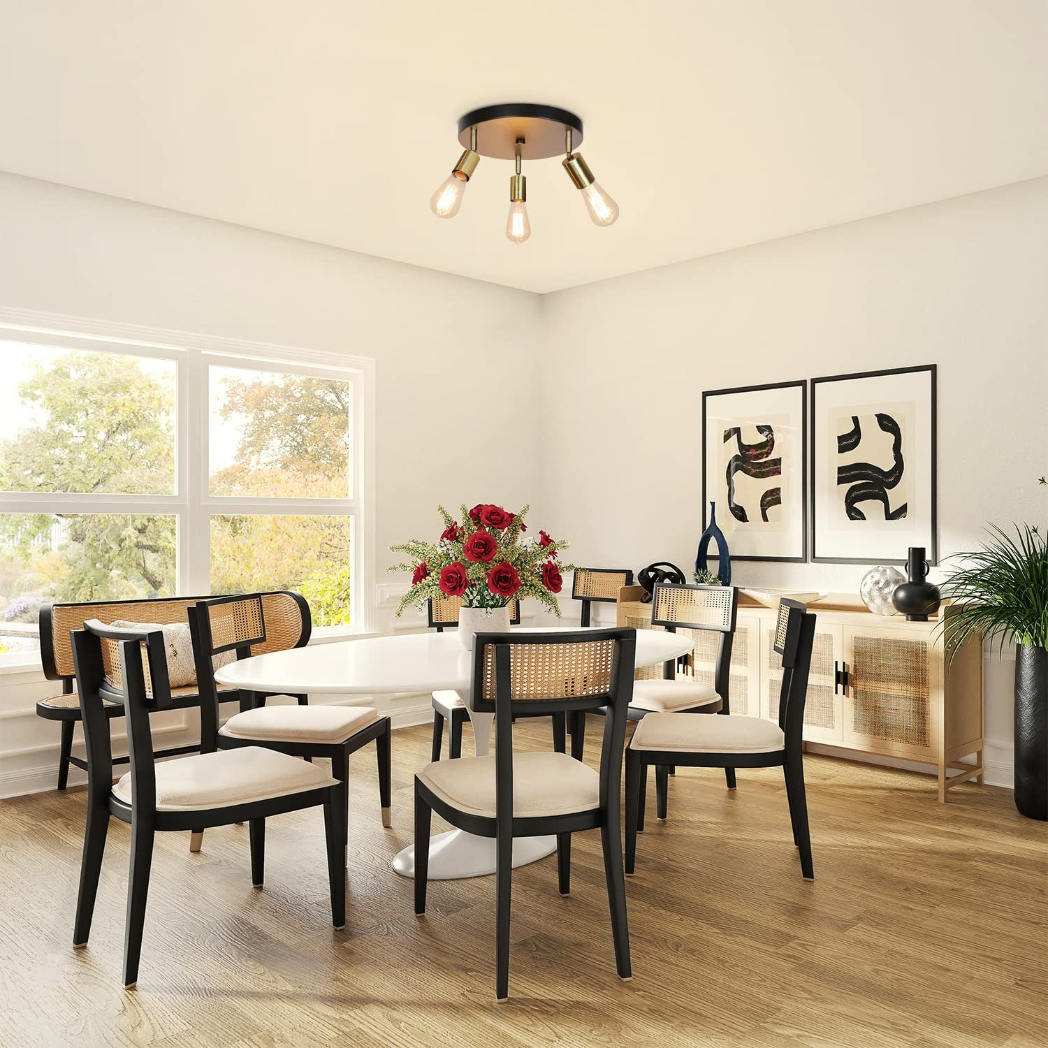 Esszimmer mit weißem Tisch, sechs Stühlen und einer Deckenleuchte mit drei Glühbirnen.
