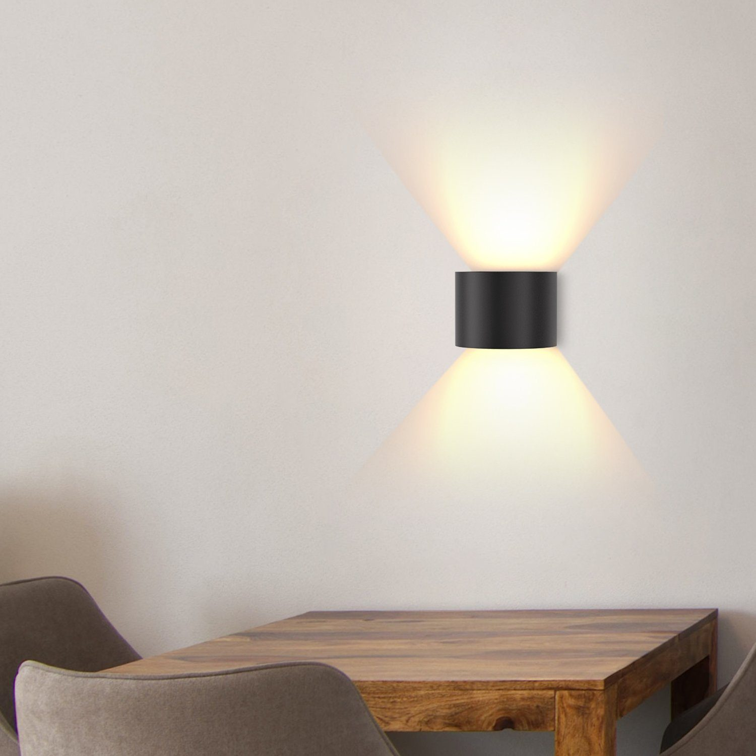 Una lampada da parete nera con fasci di luce che brillano verso il basso.