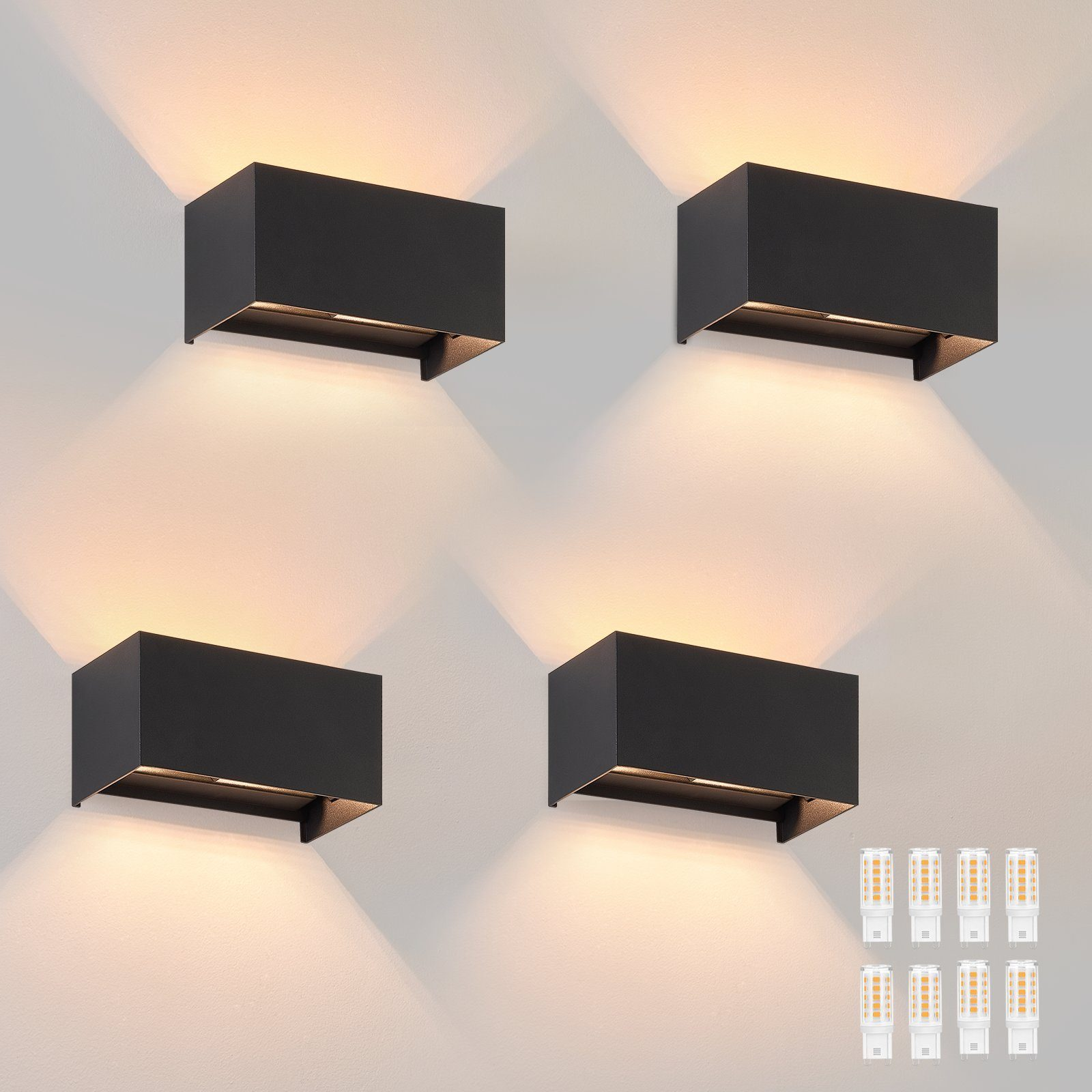 Quattro luci da parete rettangolari nere, che illuminano il muro sottostante. Alcune lampadine di ricambio.