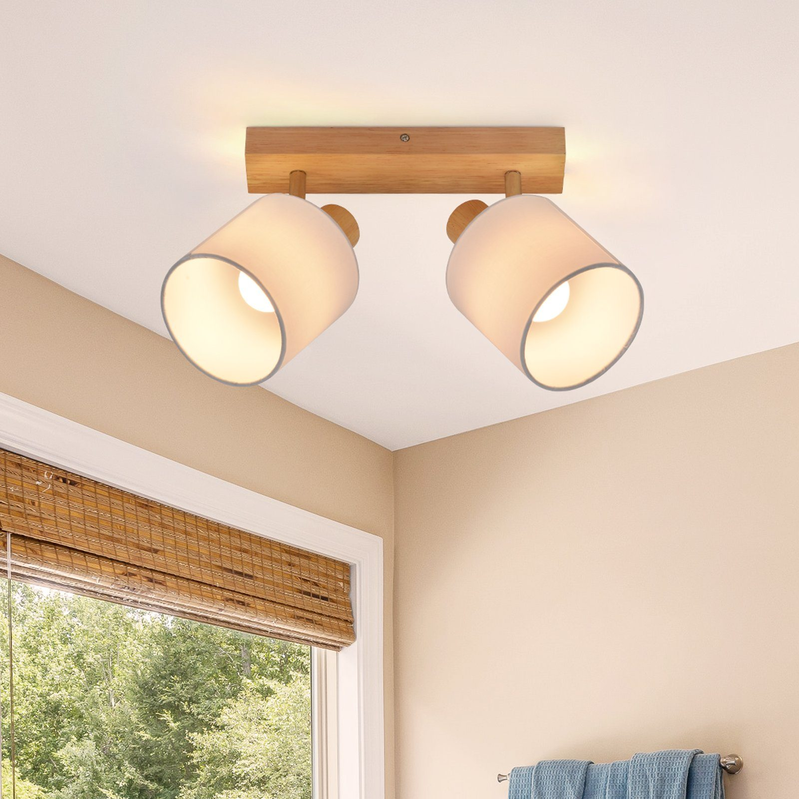 Due faretti su un soffitto in un bagno. C'è una finestra e degli asciugamani.