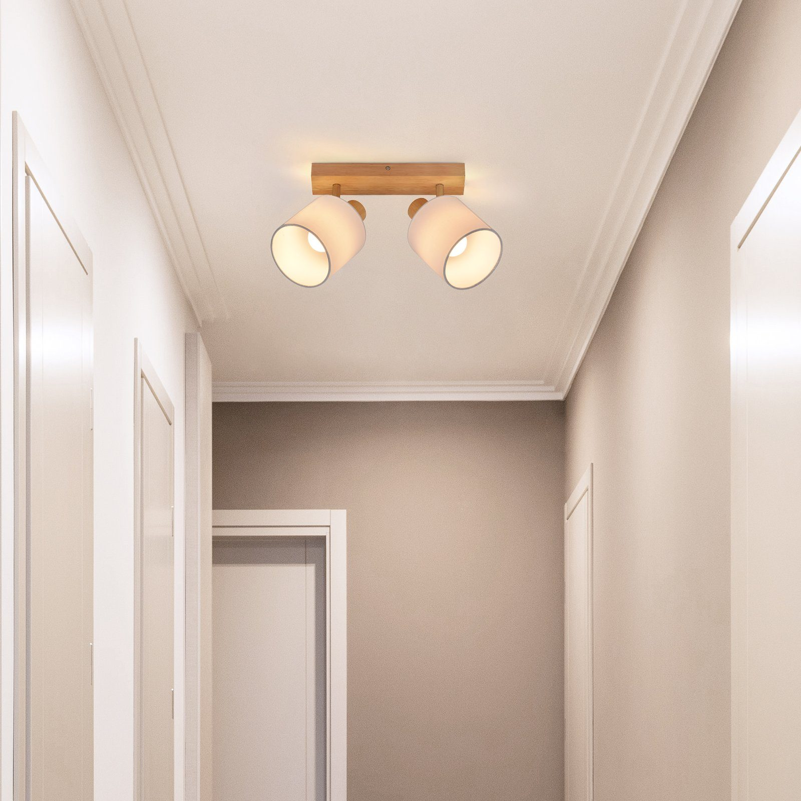Due luci a incasso sul soffitto su una tavola di legno in un corridoio con pareti e porte bianche.
