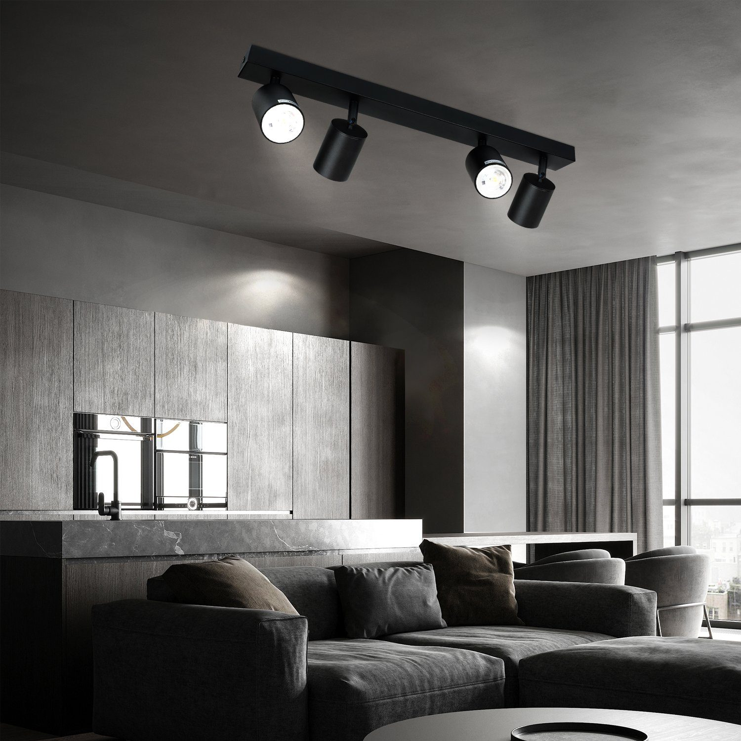 Illuminazione a binario nera con 3 faretti, diretta verso una cucina e un soggiorno scuri.