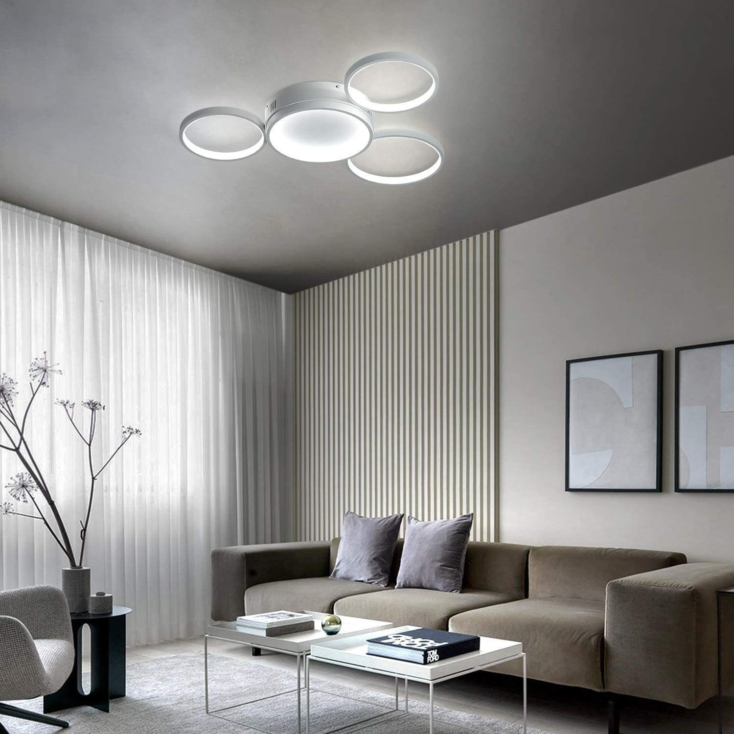 Un soggiorno con una lampada da soffitto bianca e un divano grigio, con una parete a strisce verde chiaro.