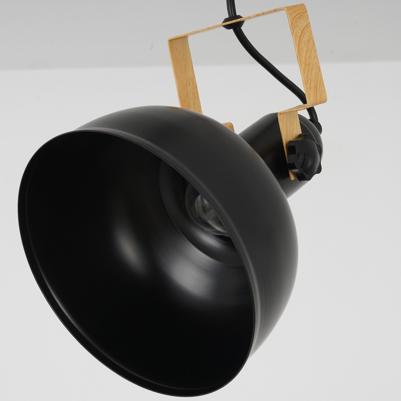 Czarna lampa z drewnianym wspornikiem. Żarówka widoczna. Białe tło.