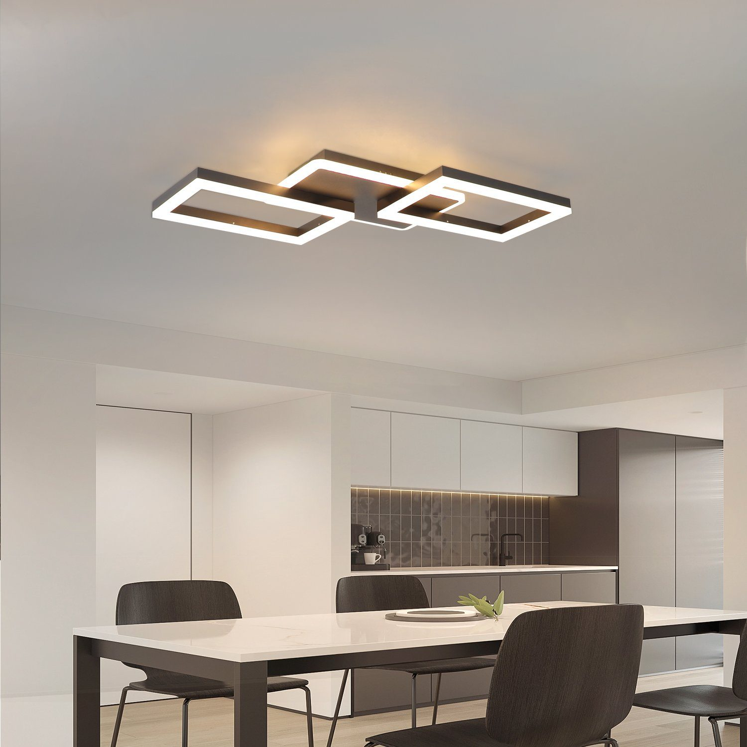 Una cucina moderna con un lampadario a soffitto. C'è un tavolo da pranzo con sedie e armadi bianchi.