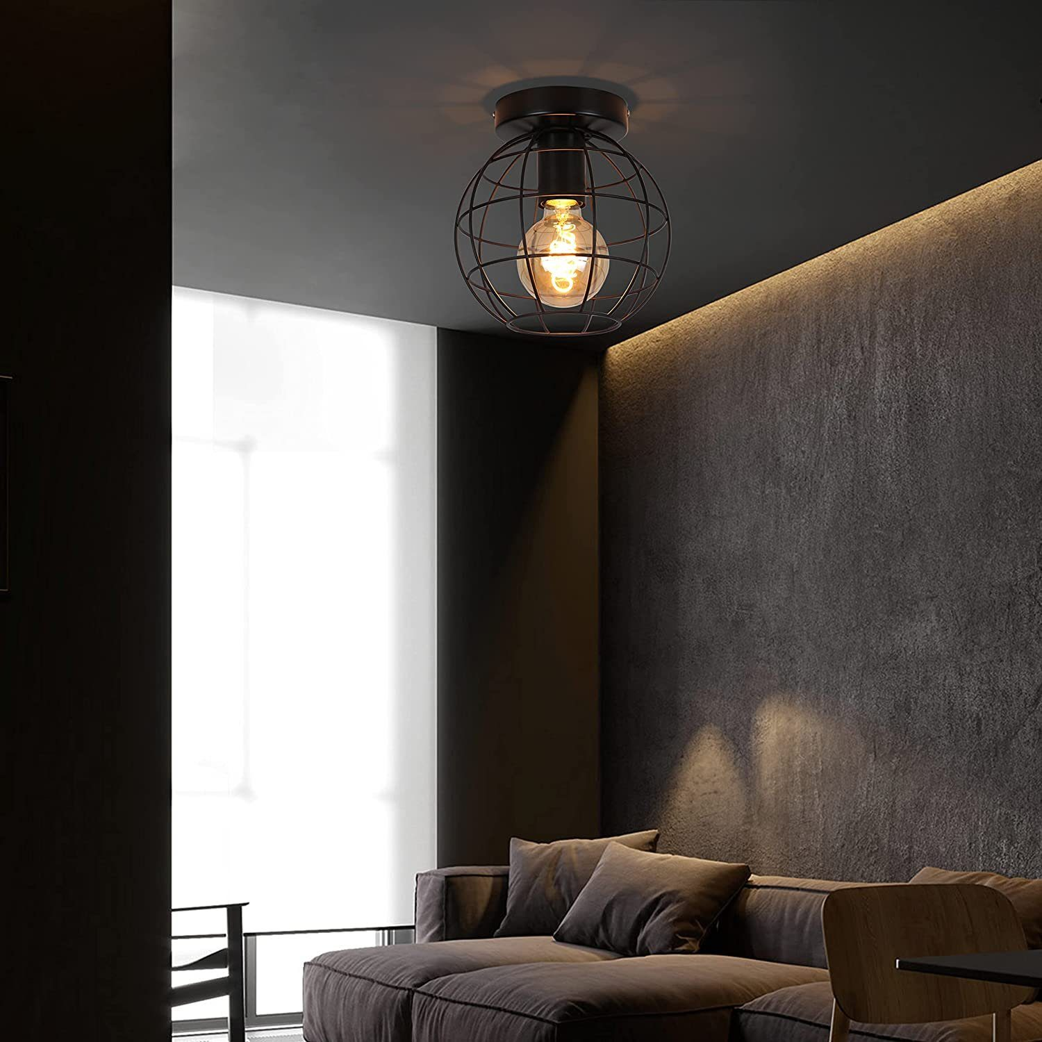 Un soggiorno con soffitto scuro e un apparecchio di illuminazione a forma di gabbia con una lampadina visibile.