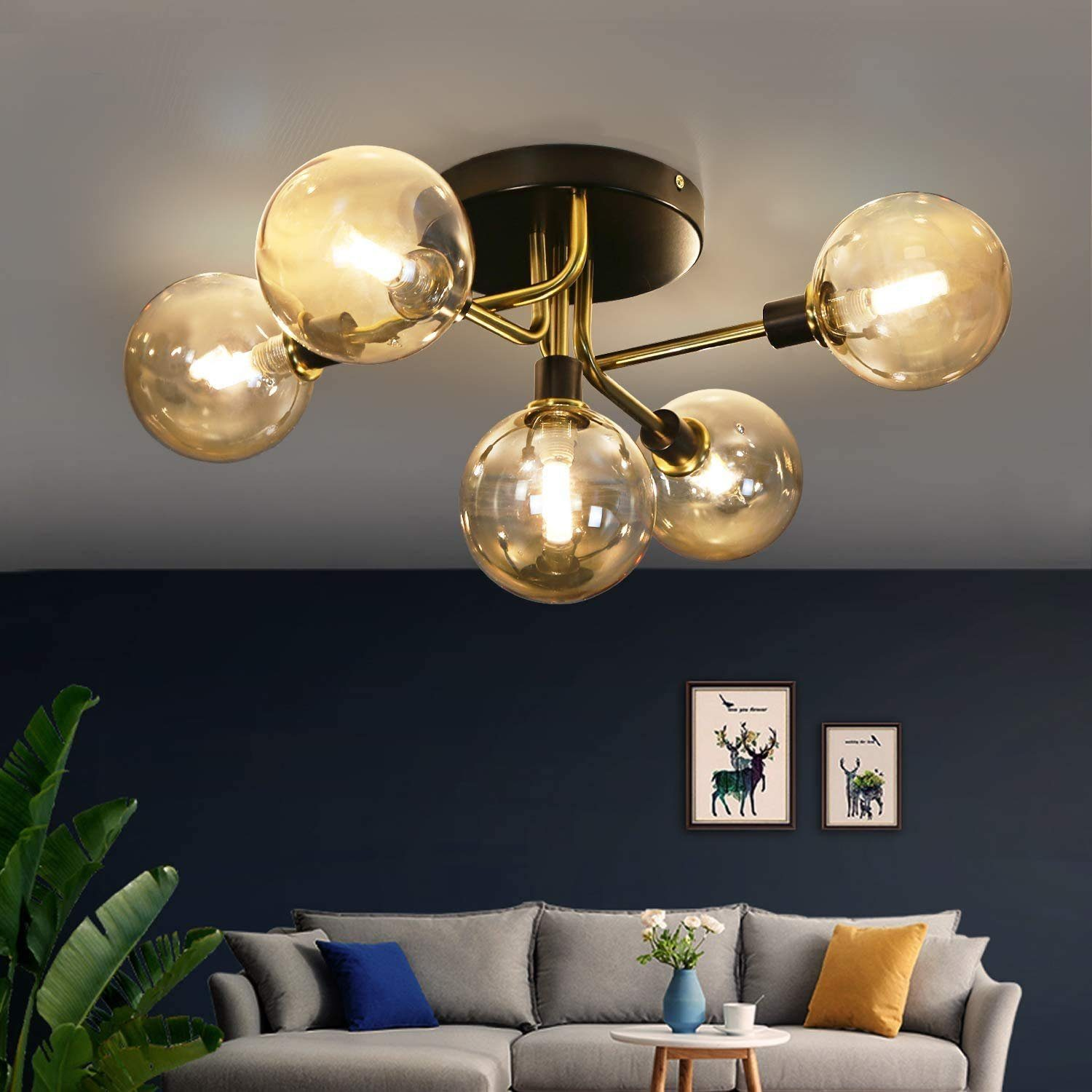 Lampa sufitowa z pięcioma żarówkami w kształcie kuli, z ciemnoniebieską ścianą w tle.