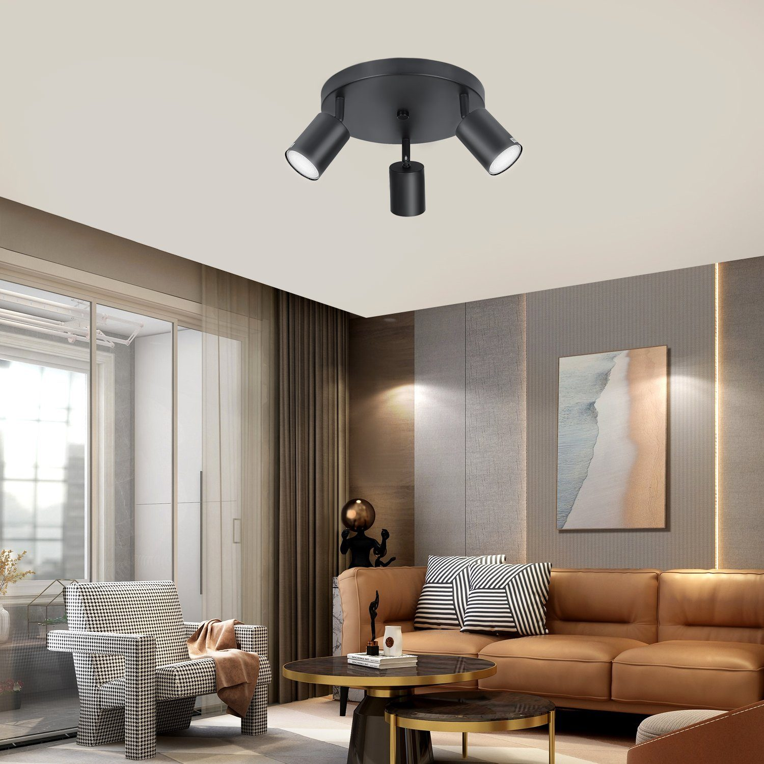 Soggiorno con faretto a soffitto, divano marrone e dipinto sulla parete.