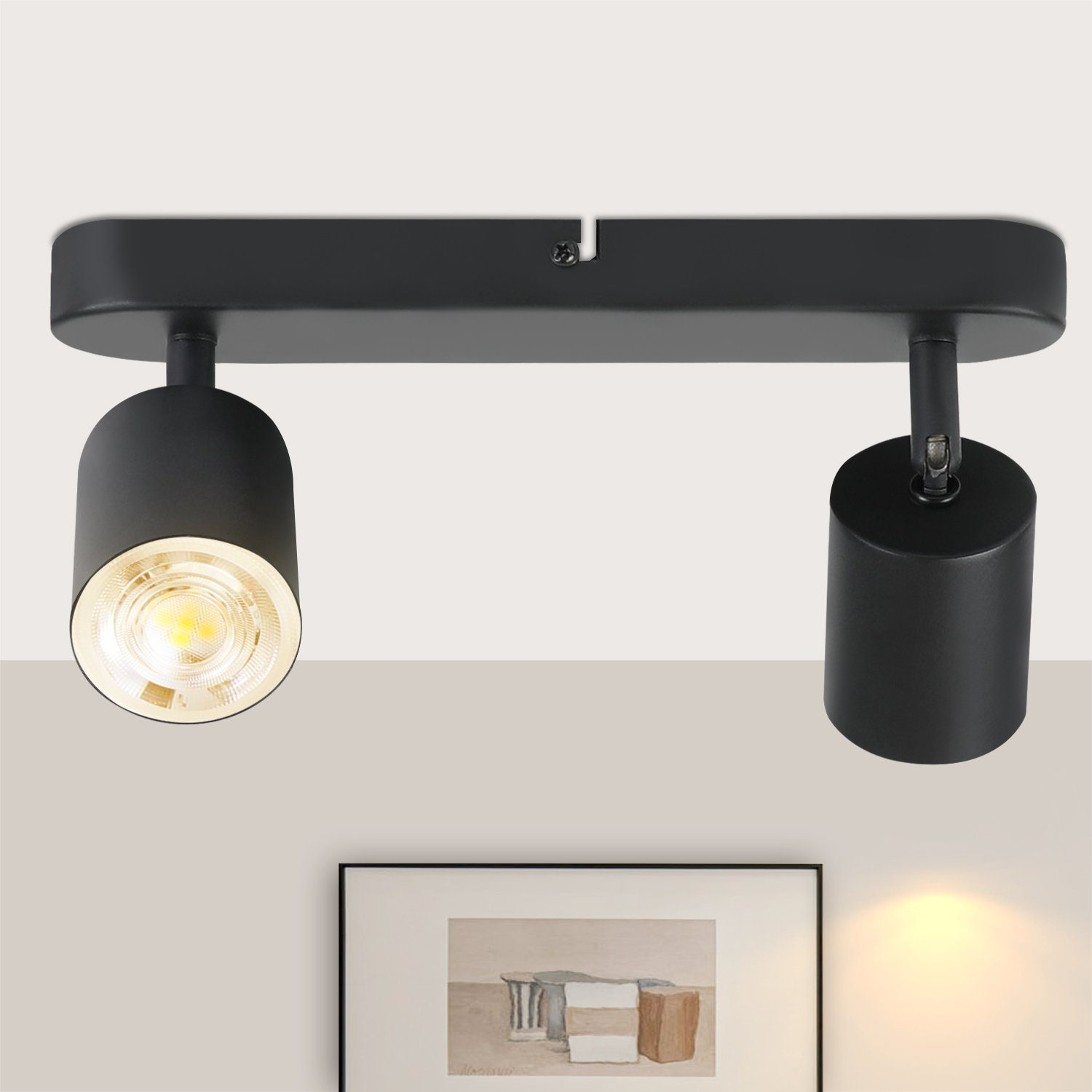 Faretti neri su una rotaia, illuminanti. Sfondo: un disegno.