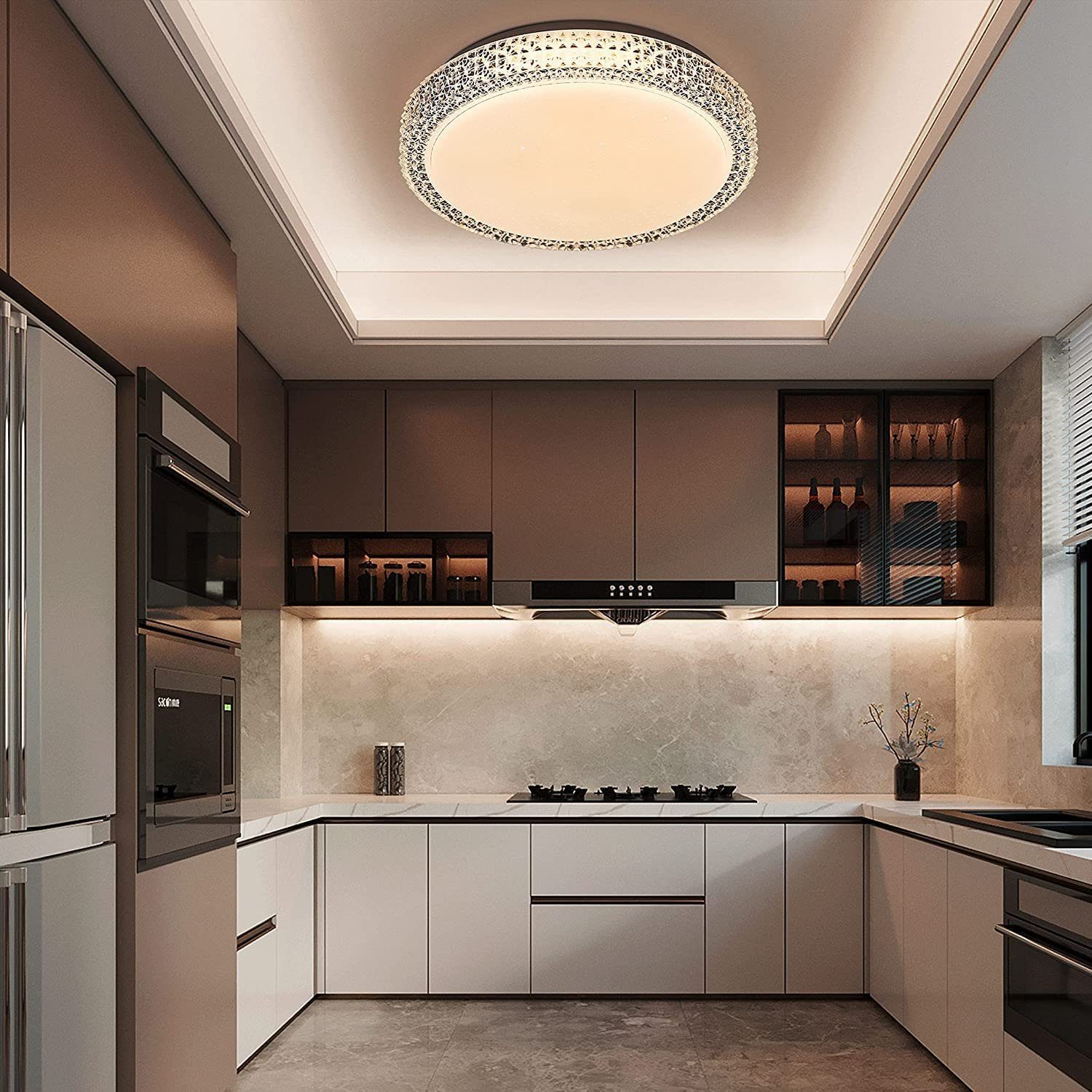 Una cucina moderna con mobili bianchi, un paraschizzi in marmo e una luce a soffitto circolare.