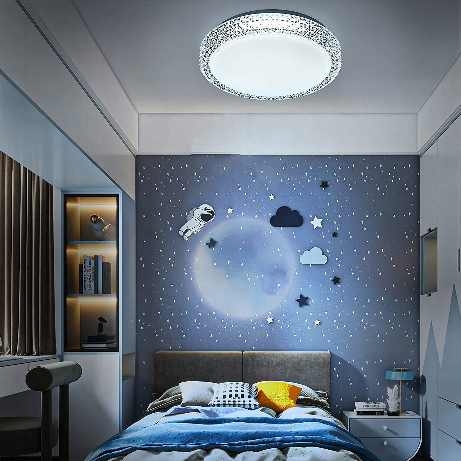 Camera da letto con arte murale a tema stelle, un letto e una moderna lampada da soffitto.