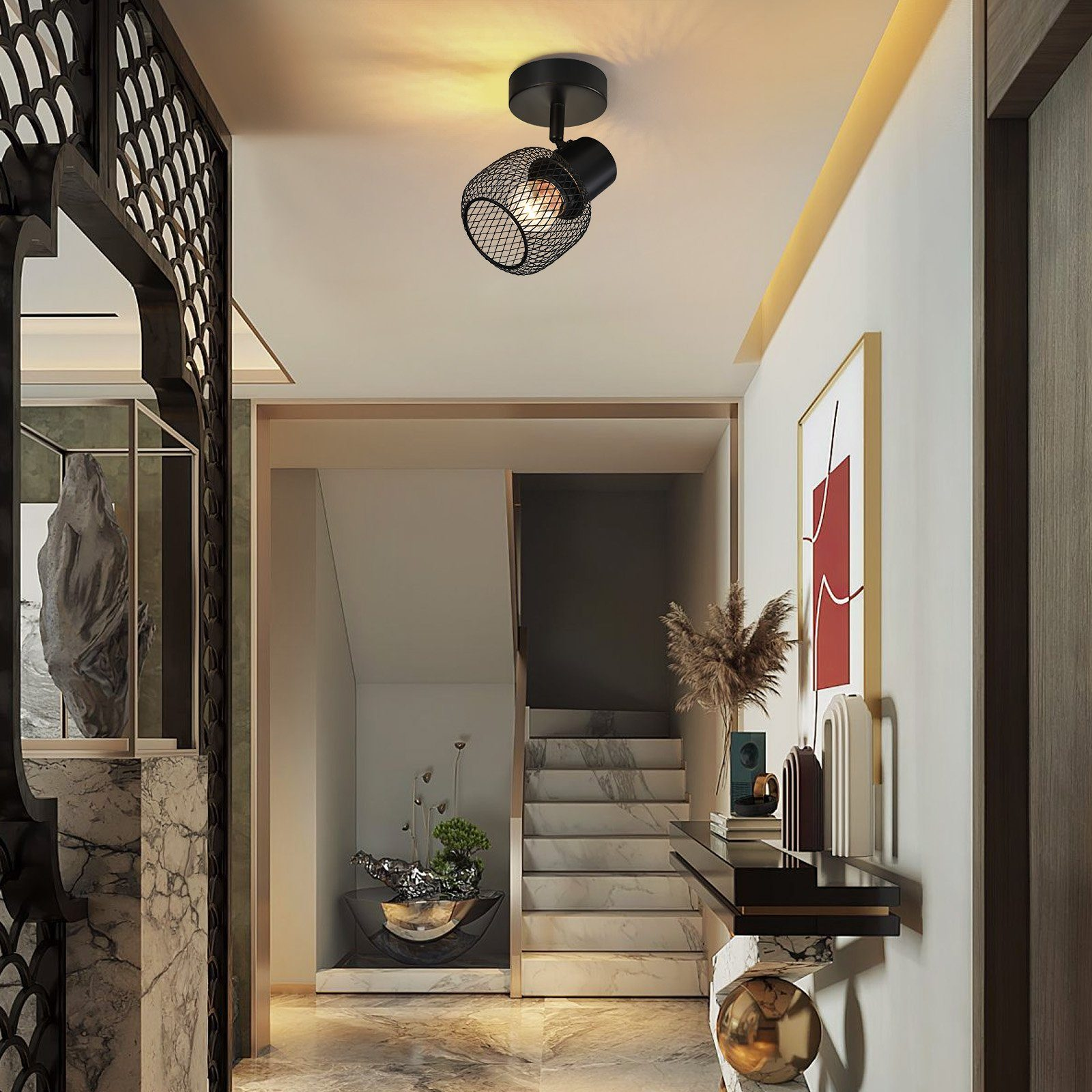 Un corridoio moderno con un faretto a soffitto, una scala e una parete decorativa.