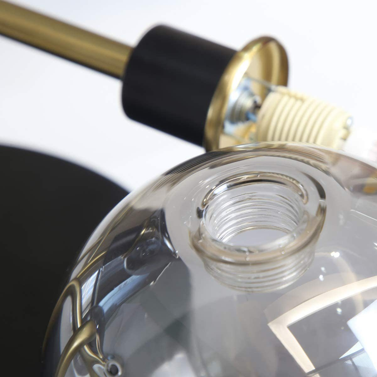 Zbliżenie podstawy żarówki. Pokazuje wewnętrzne elementy żarówki i złoty element.