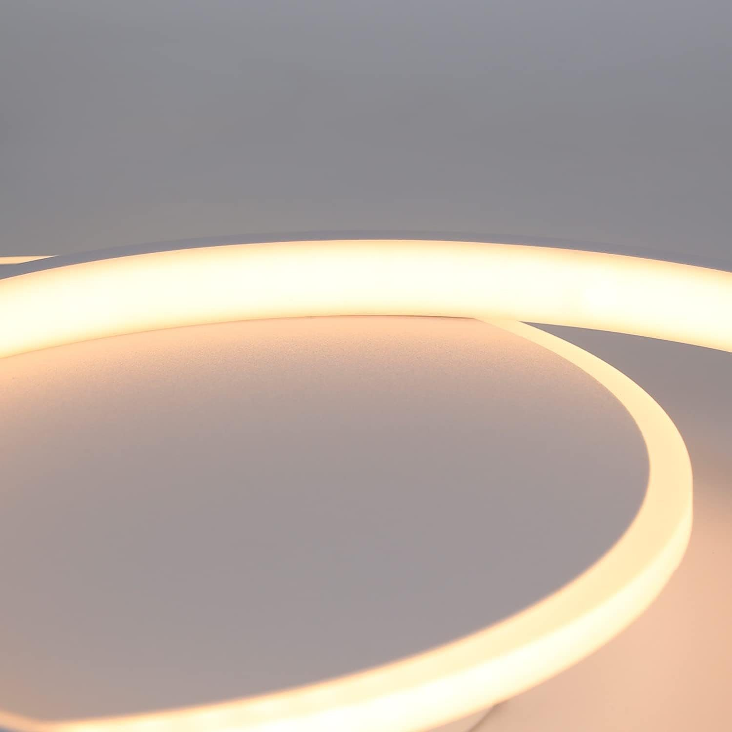 Un primo piano di una moderna lampada da soffitto bianca con un design curvo e illuminato. Viene emessa luce soffusa.
