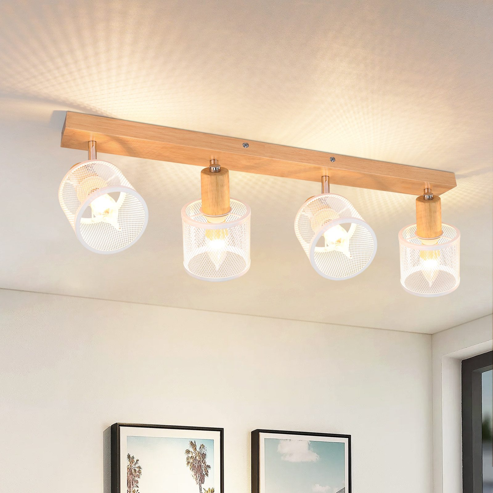 Trave in legno con quattro lampade in metallo bianco con perforazioni, ciascuna con una lampadina.