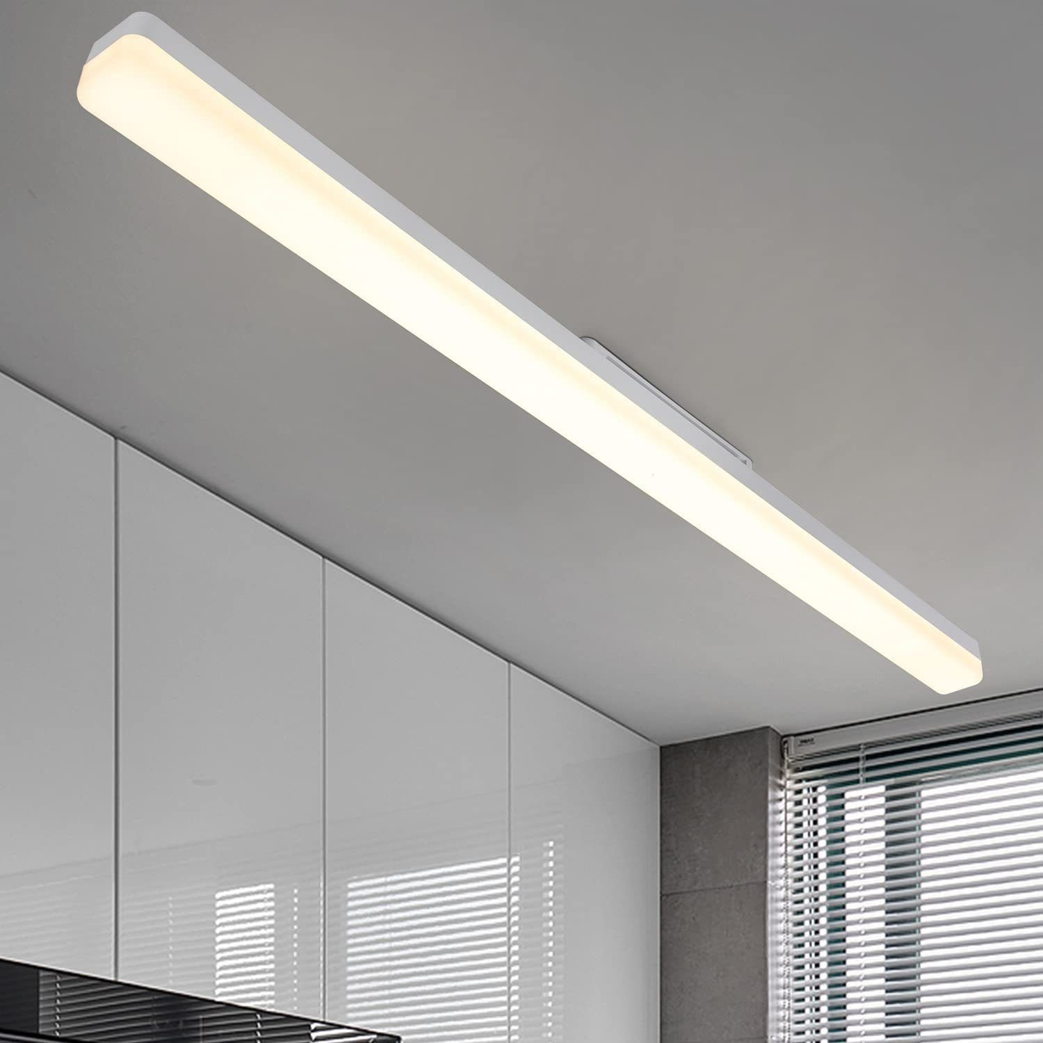 Długa biała lampa sufitowa LED w kuchni, białe szafki i żaluzje.