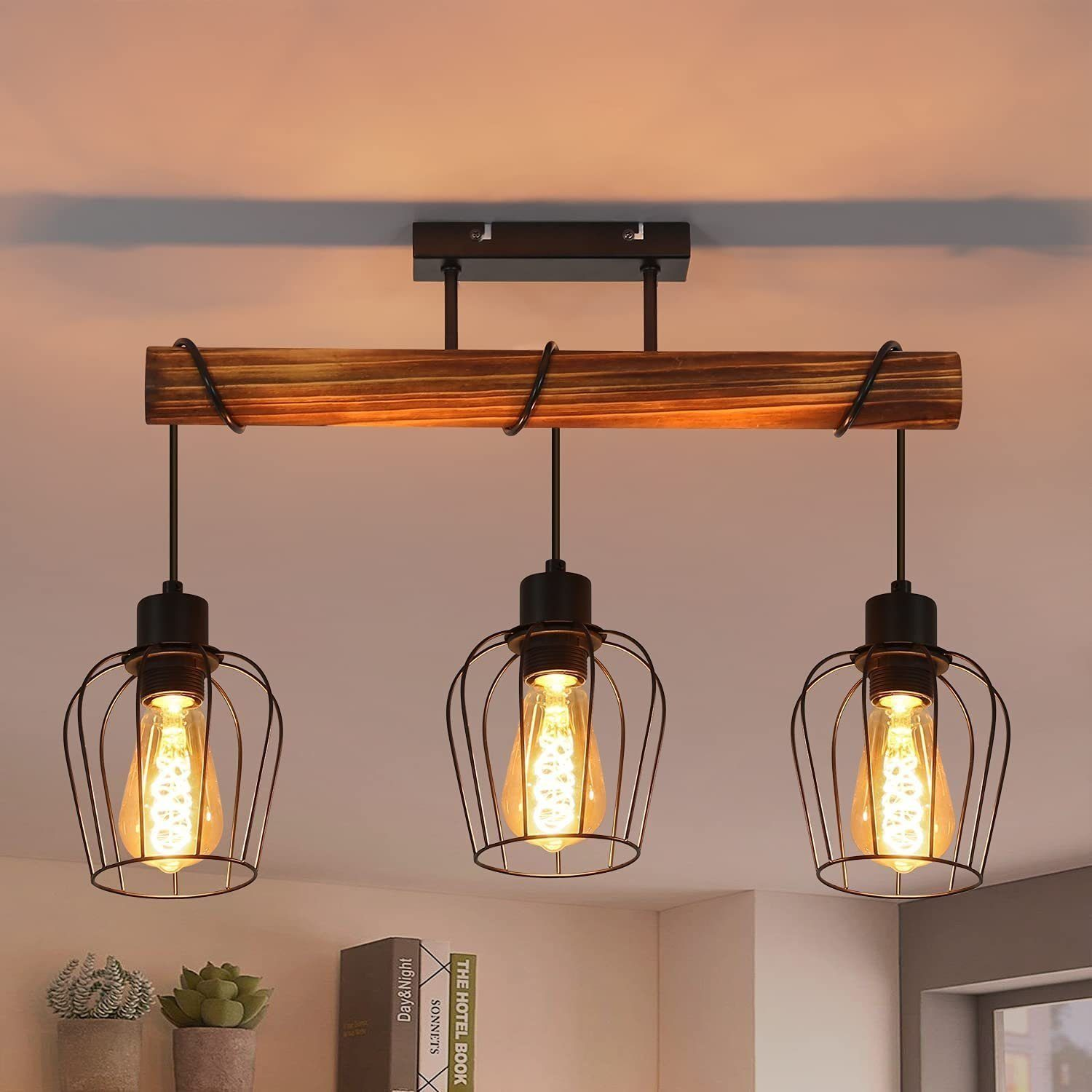 Una plafoniera a trave in legno con tre luci a sospensione, ciascuna con una gabbia e una lampadina visibile.