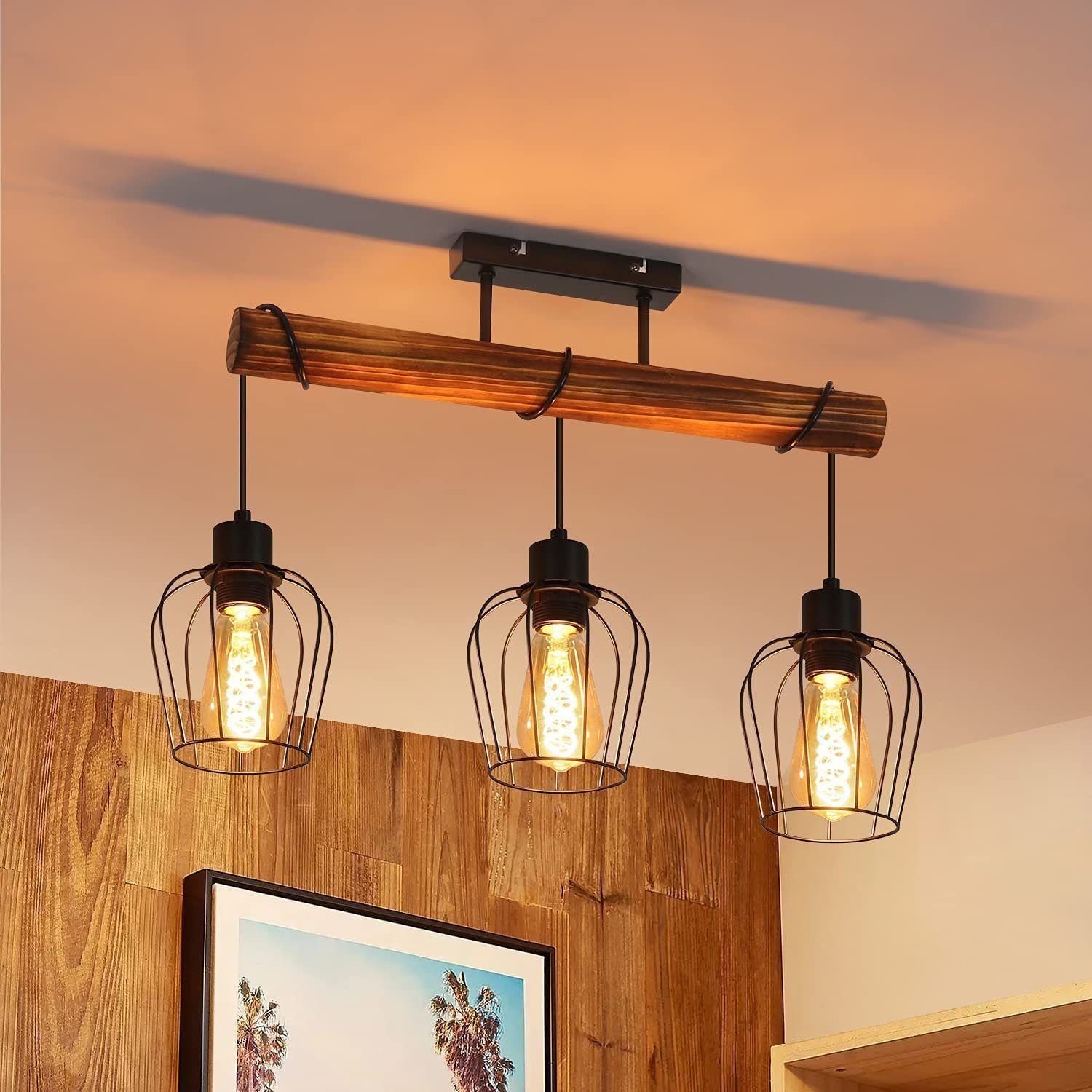 Una trave in legno con tre luci a gabbia nere sospese, che proiettano ombre sul soffitto.