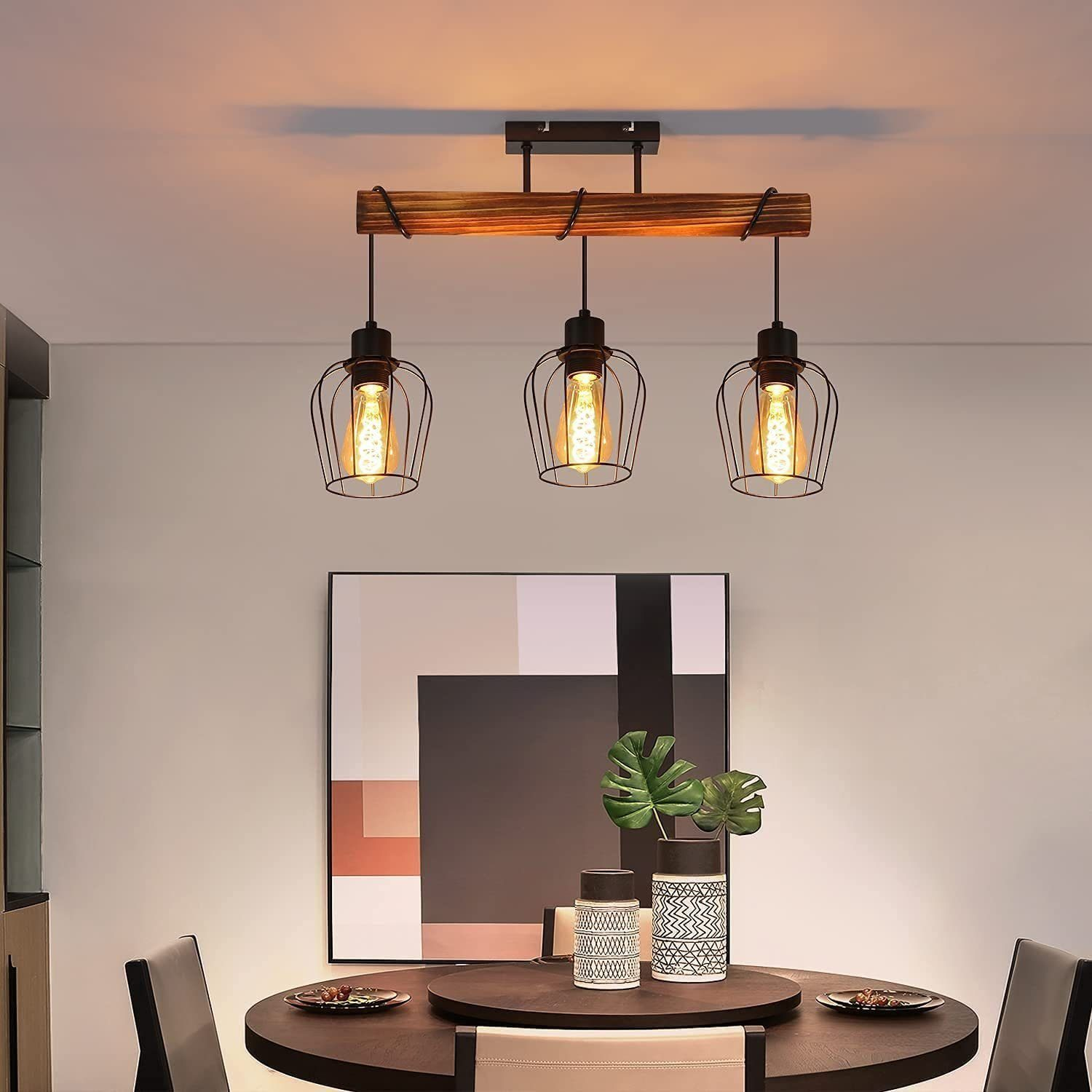 Una sala da pranzo con un lampadario a trave di legno con tre lampadine Edison. Sono visibili anche un tavolo e sedie.