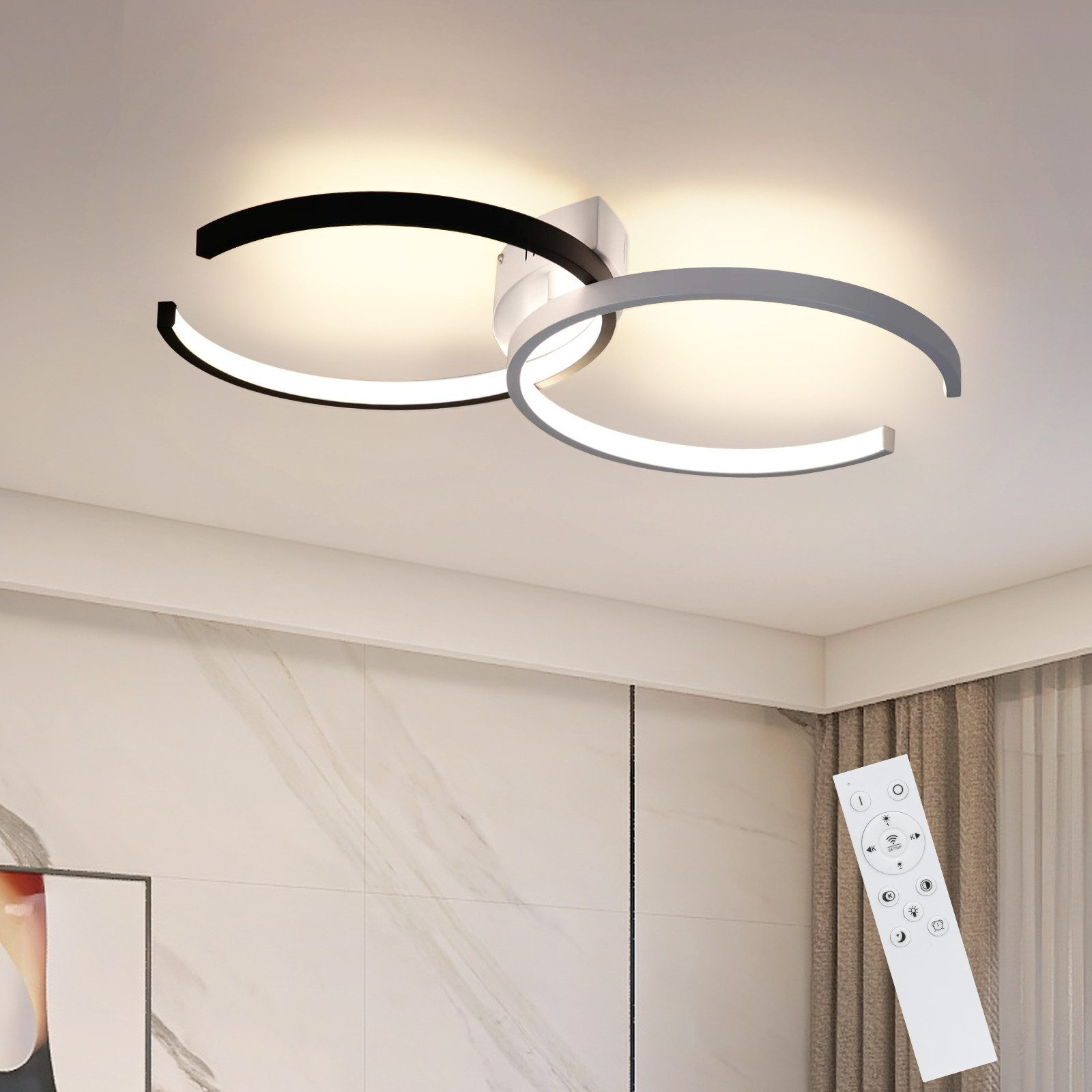 Lampada da soffitto moderna con tre anelli curvi illuminati. Un telecomando è in primo piano.