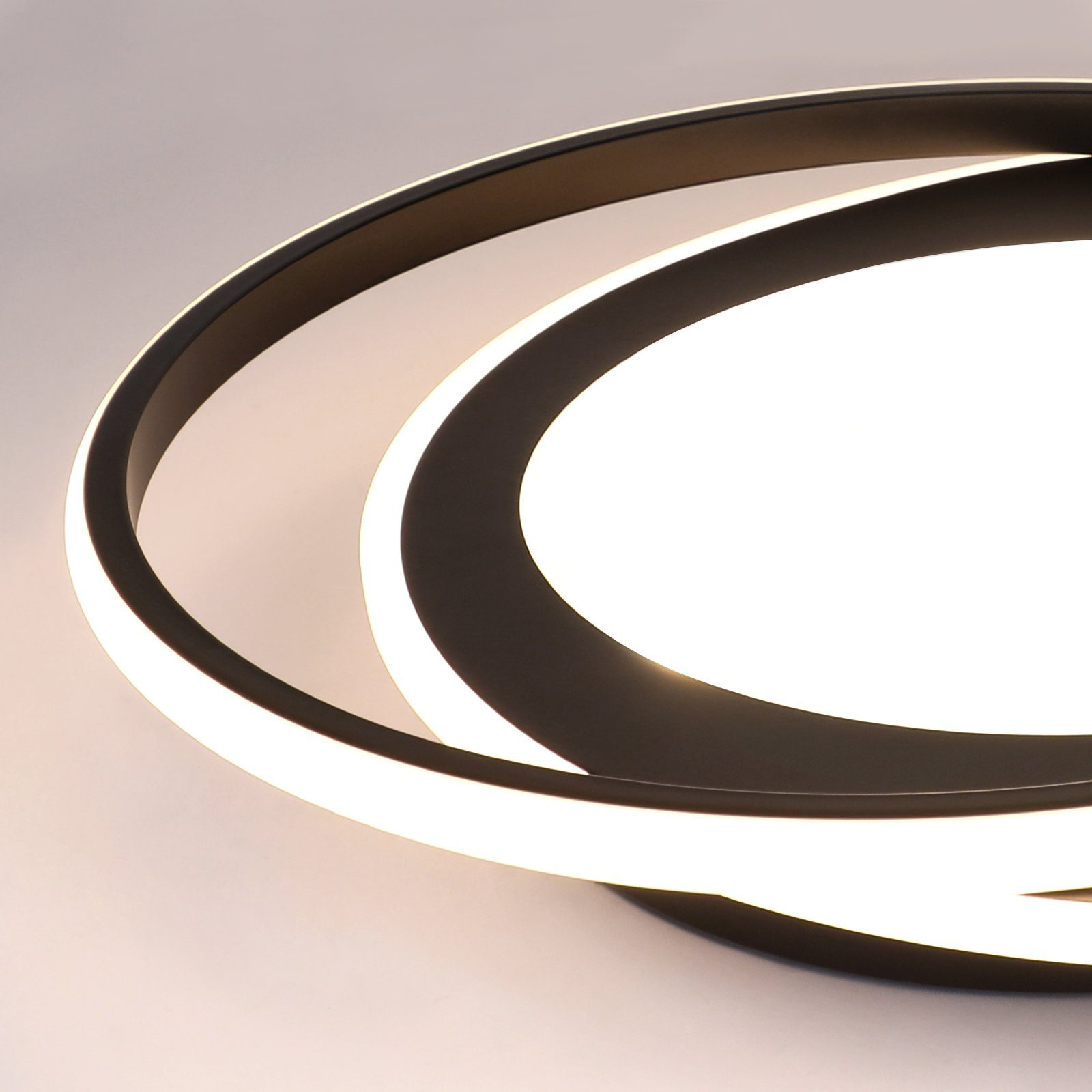 Primo piano di una moderna lampada da soffitto in bianco e nero con due forme circolari ad incastro.