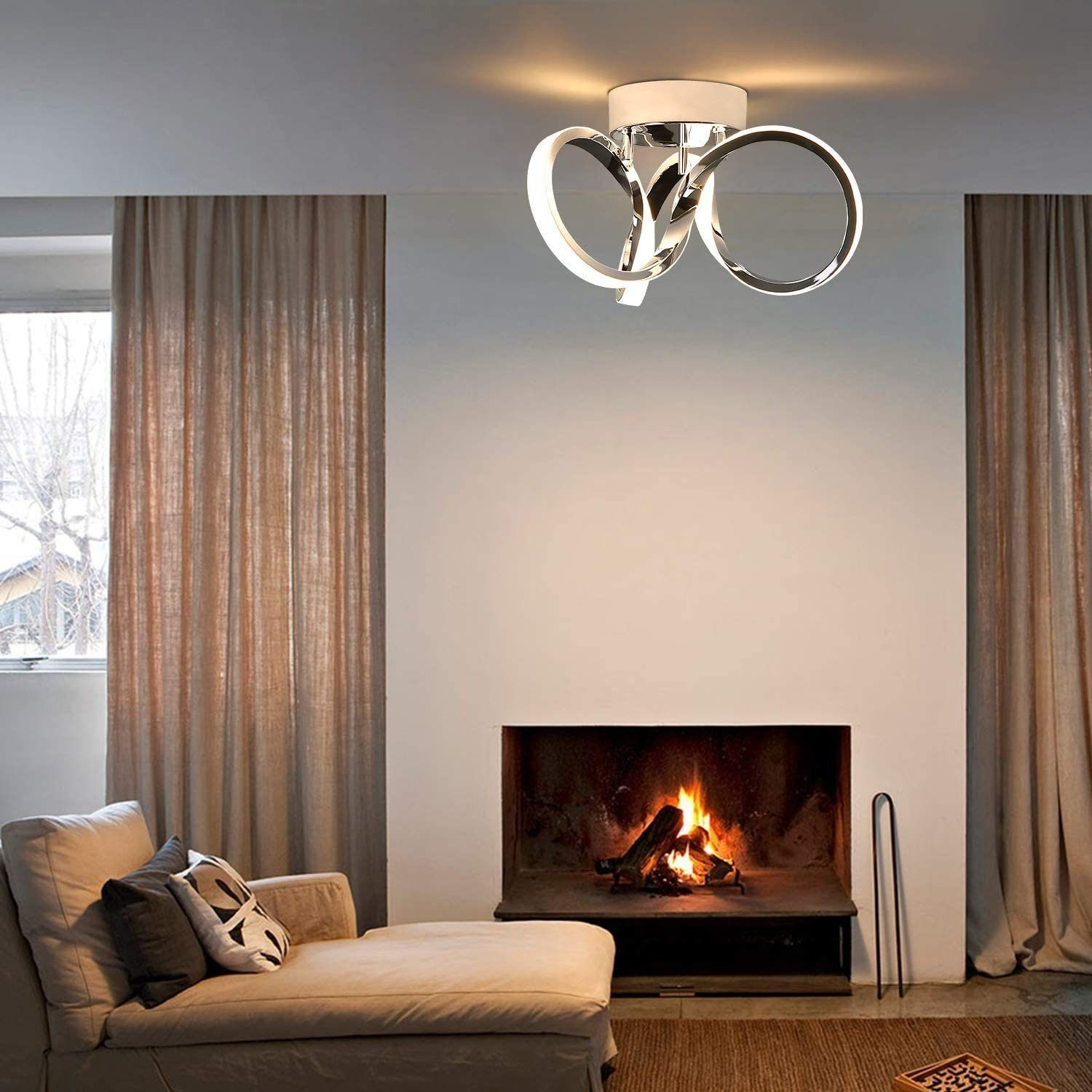 Lampada da soffitto moderna con tre anelli argentati. Un camino con fuoco, tende.