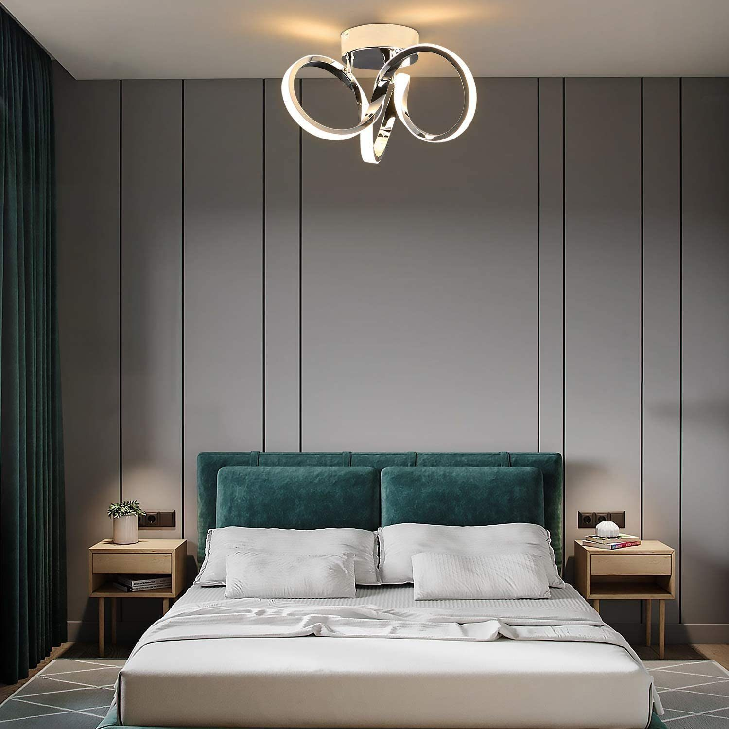 Camera da letto con parete d'accento grigia, letto e lampada da soffitto moderna con tre anelli.