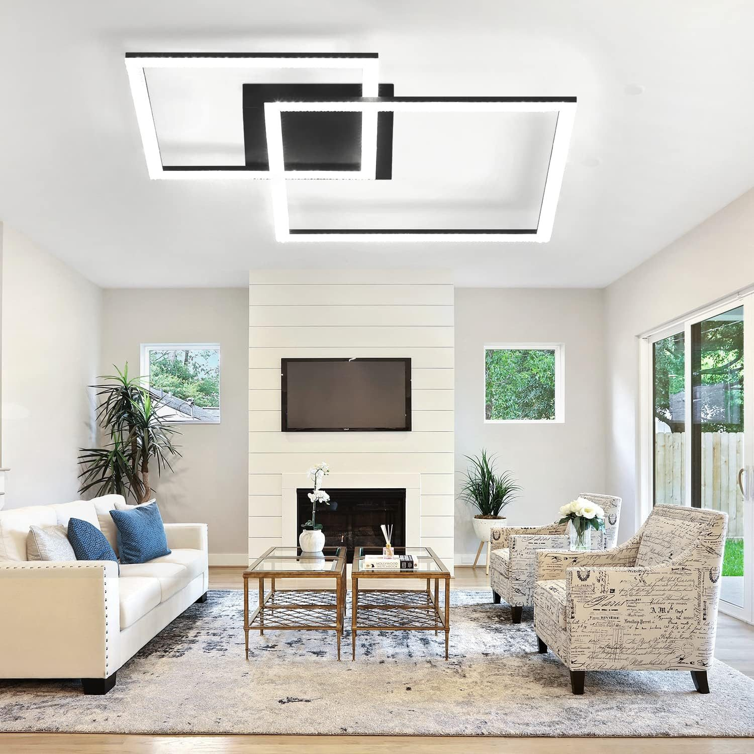 Un soggiorno con una moderna lampada da soffitto. C'è un divano bianco, due sedie e un camino.