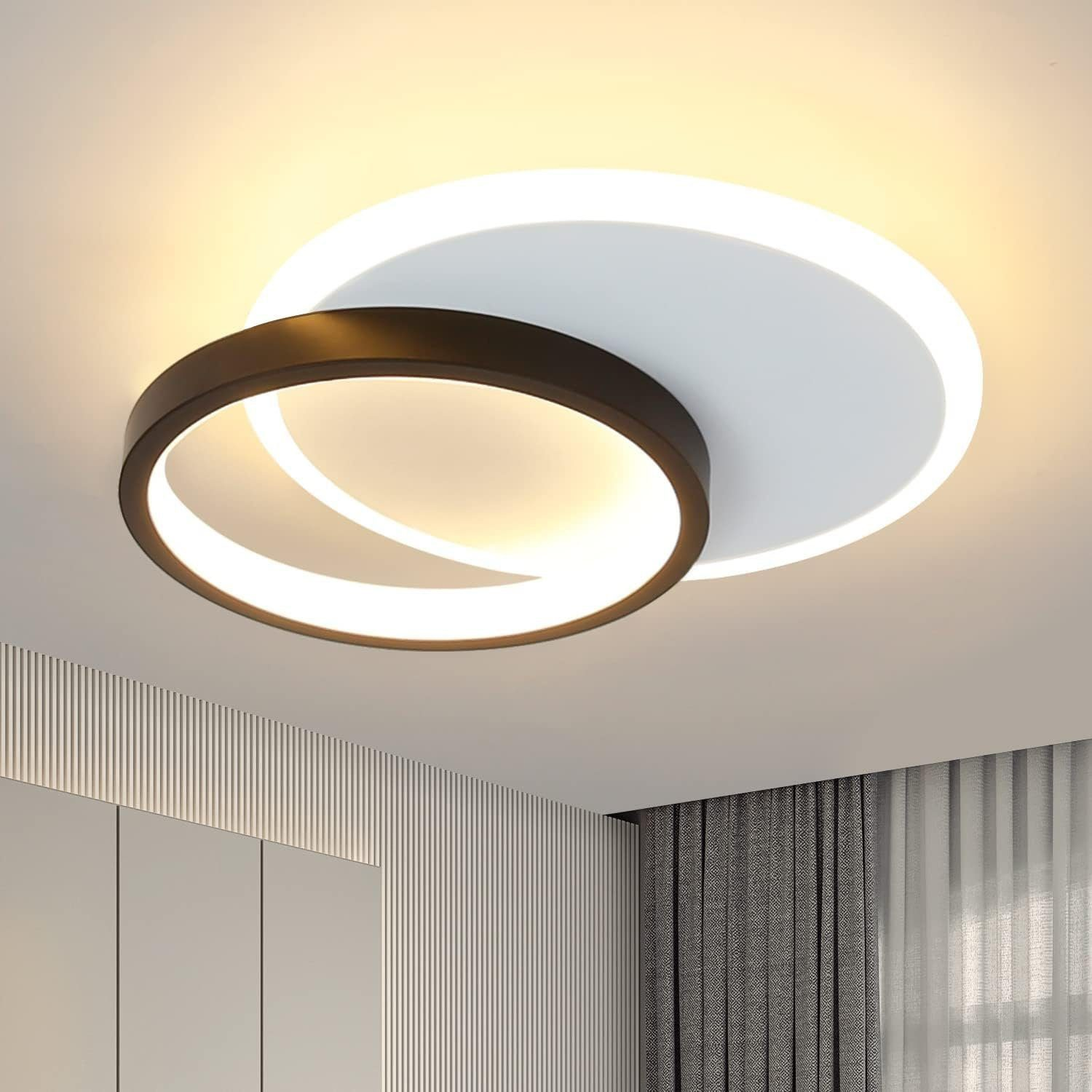 Lampada da soffitto con cerchi bianchi e neri. La luce è accesa. Il soffitto è grigio chiaro.