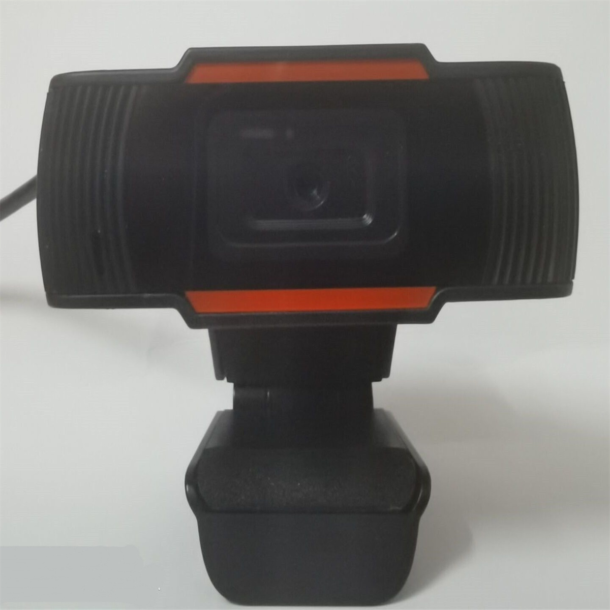 Schwarze Webcam mit orangefarbenem Streifen. Sie steht auf einer weißen Oberfläche, mit einfachem Design und drehbarer Basis.