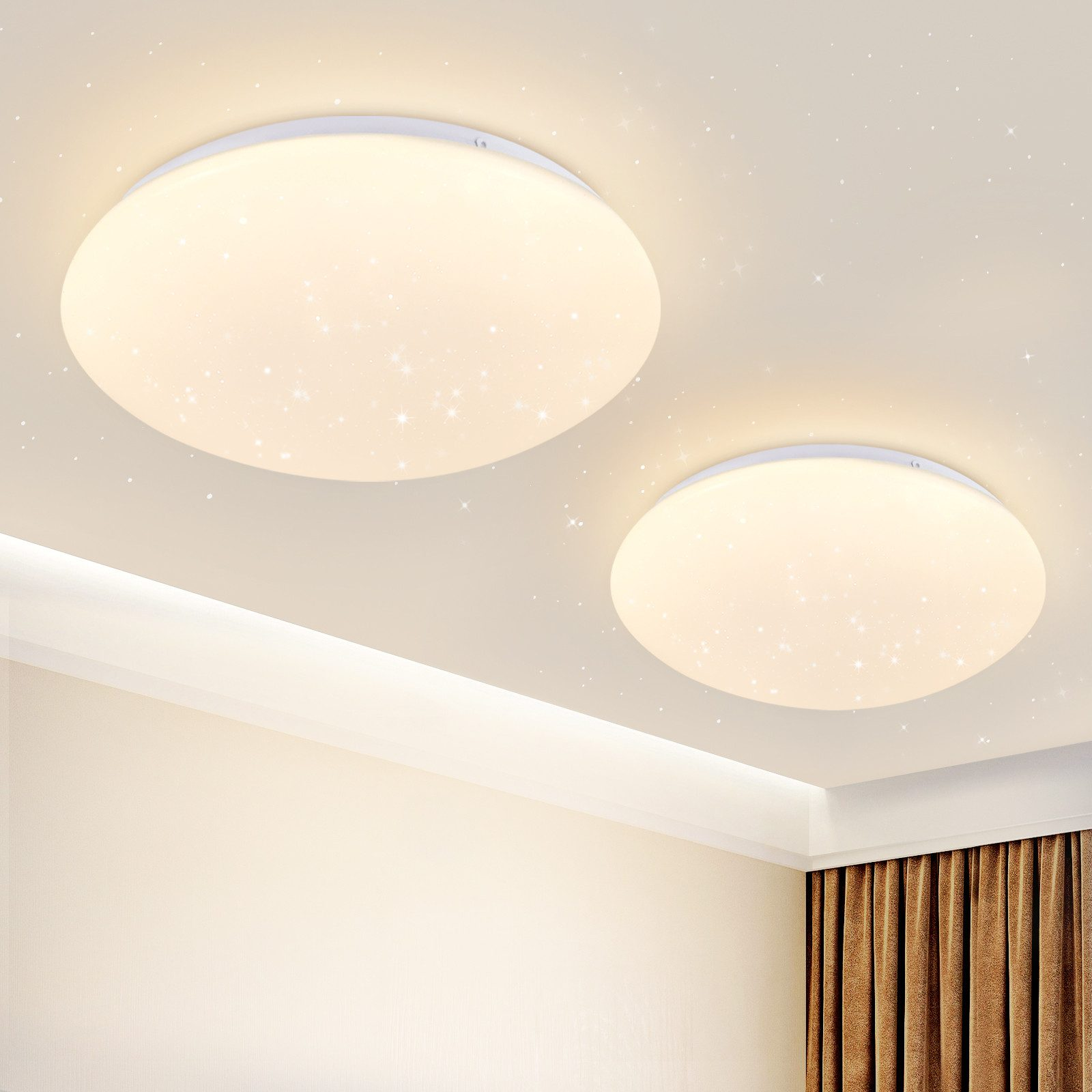 Due plafoniere circolari bianche con motivi a stella. Sfondo: pareti beige, tenda e soffitto.