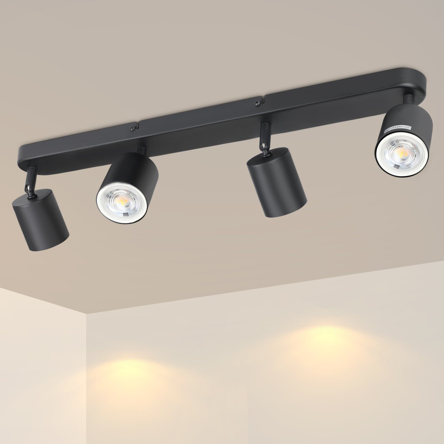 Un apparecchio di illuminazione a soffitto nero con quattro faretti regolabili su un soffitto bianco.