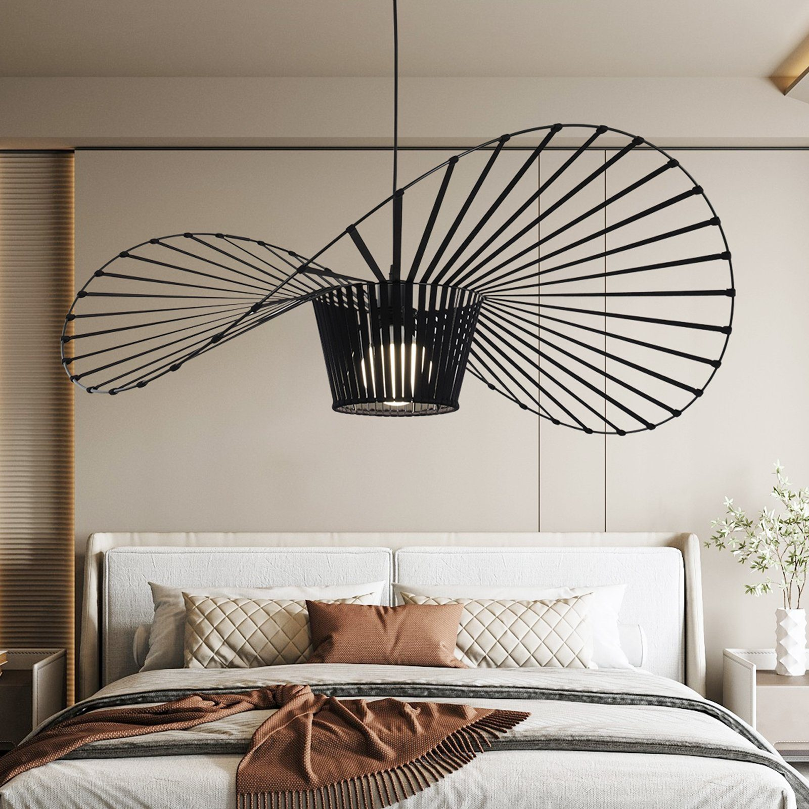 Schwarz-silberne Pendelleuchte mit einzigartigem Spiraldesign, über einem Bett hängend.