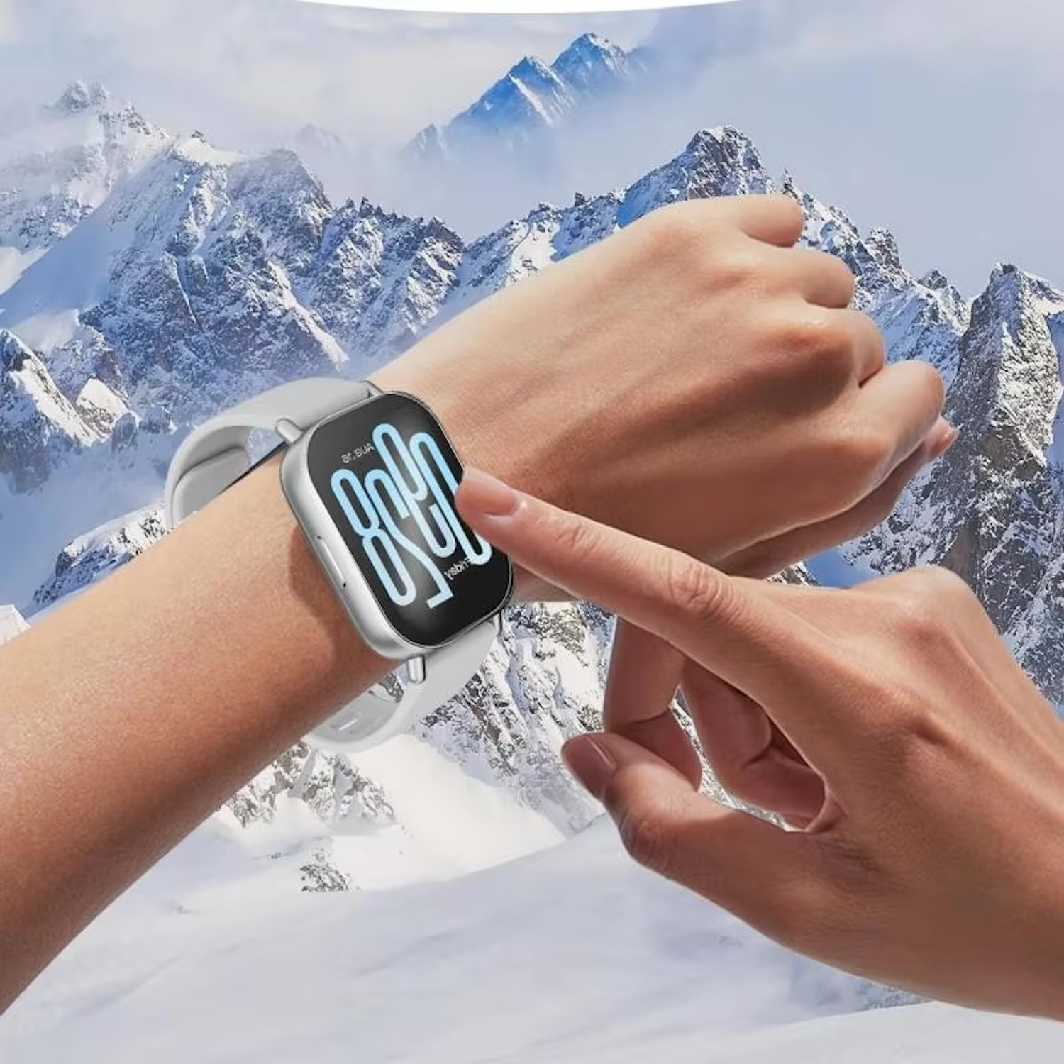 Handgelenk mit Smartwatch. Schneebedeckte Berge im Hintergrund.